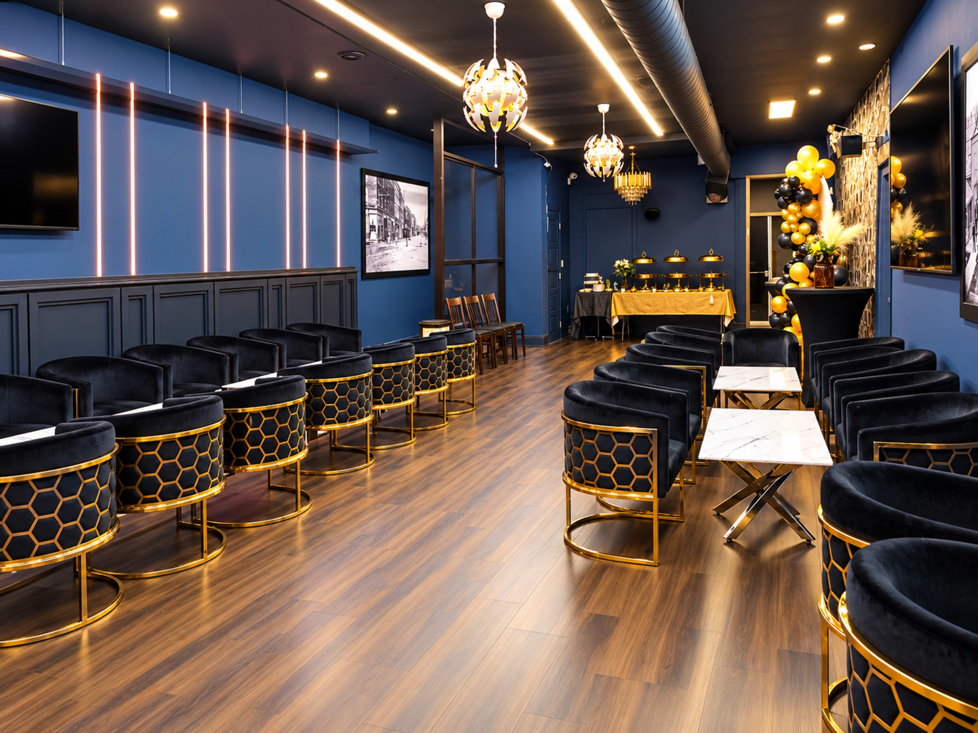 The image shows a modern lounge area with dark blue walls, stylish seating arranged in rows, and elegant lighting fixtures.