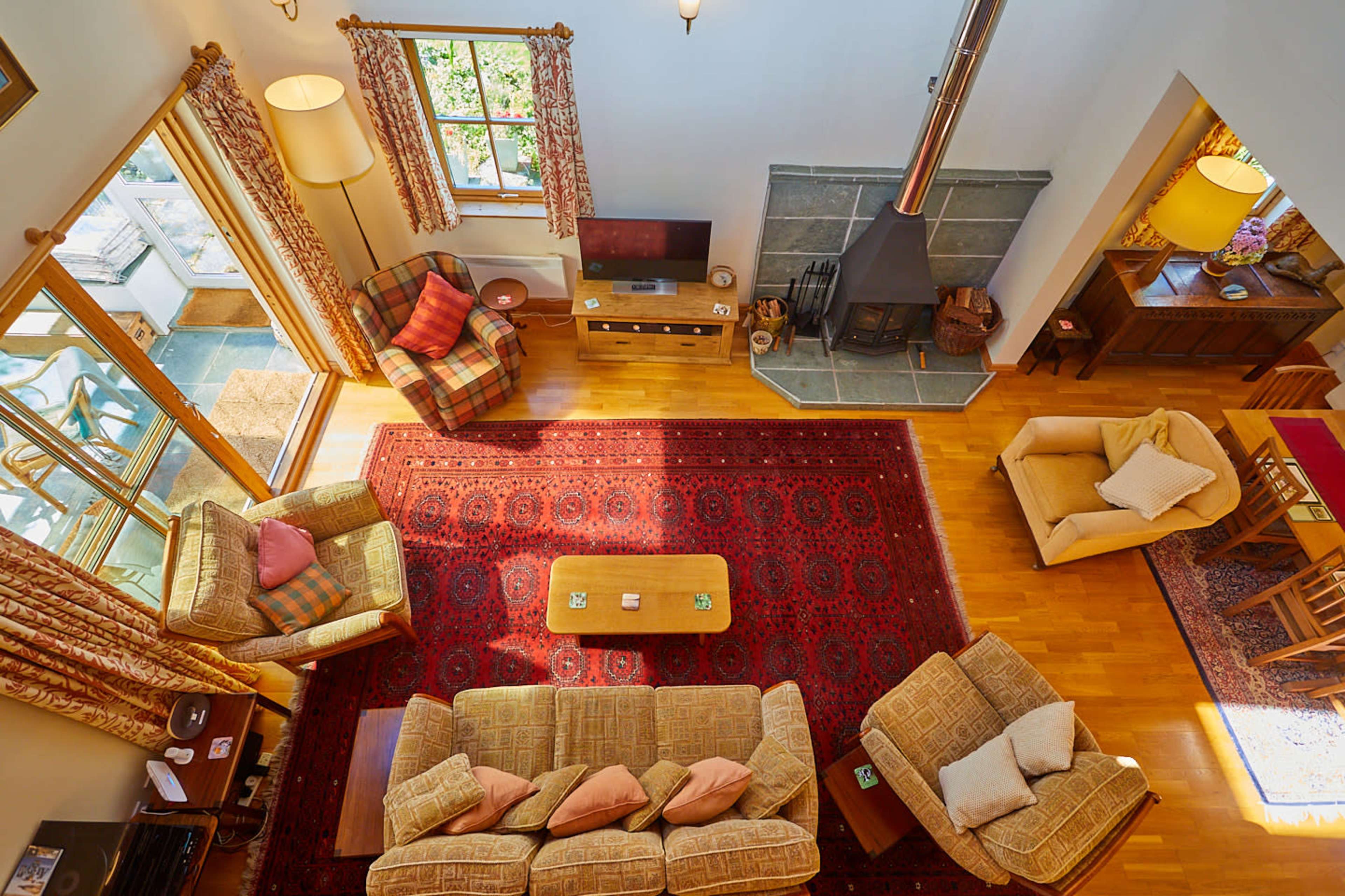 A spacious living area with a fireplace, comfortable seating arrangements, and a large area rug.