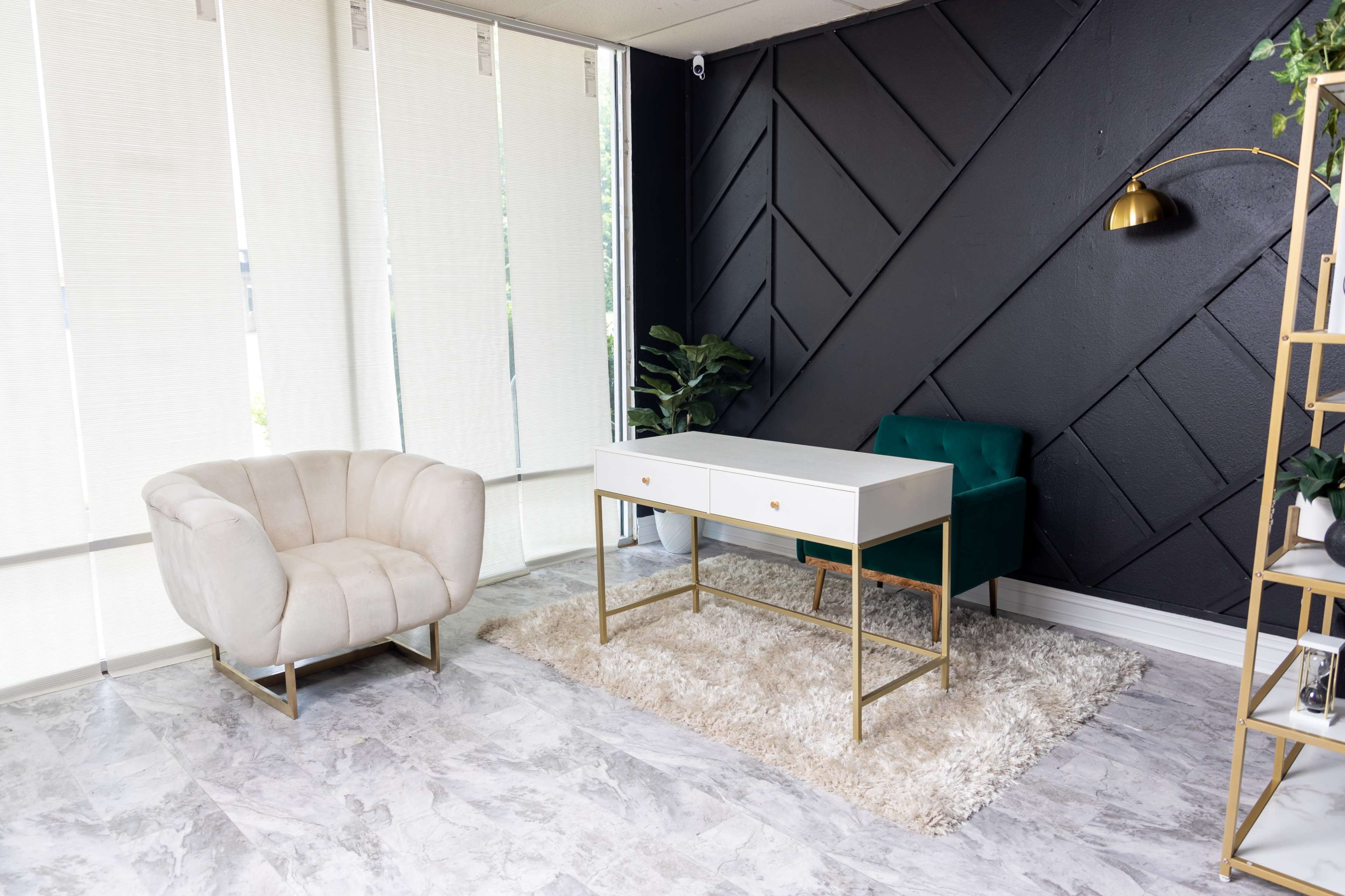 The image shows a modern interior space with a white table, two chairs in contrasting colors, a rug on a tiled floor, and a floor lamp beside a green plant.
