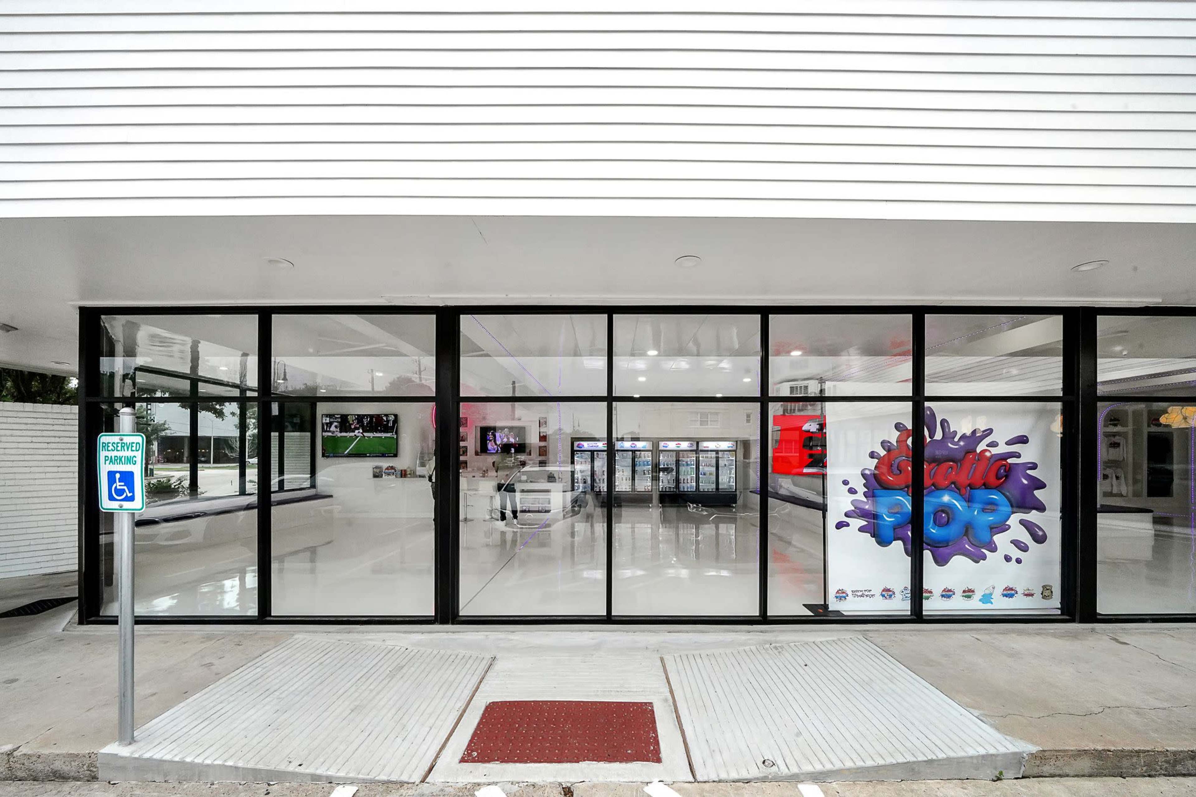 A modern retail store with large glass windows and a colorful sign that reads "Exotic Pop" on the front wall.
