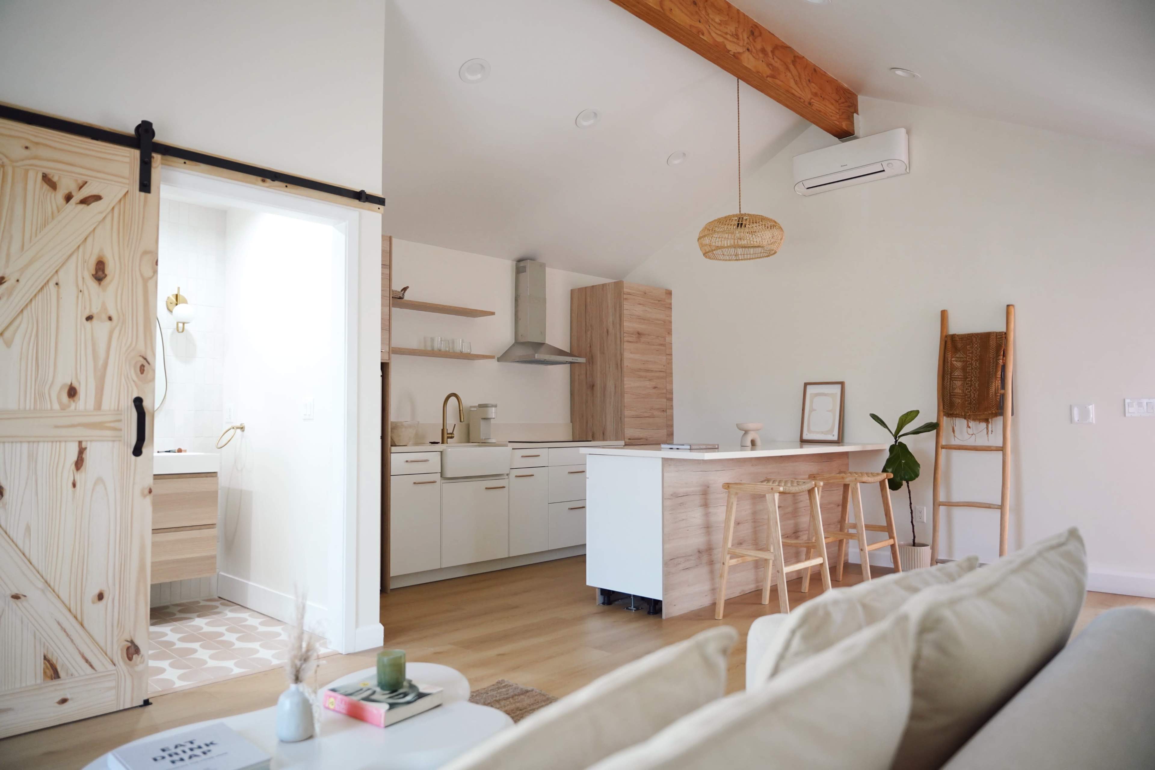 A modern open-concept living space featuring a kitchen with a large island, wooden accents, and a cozy seating area.