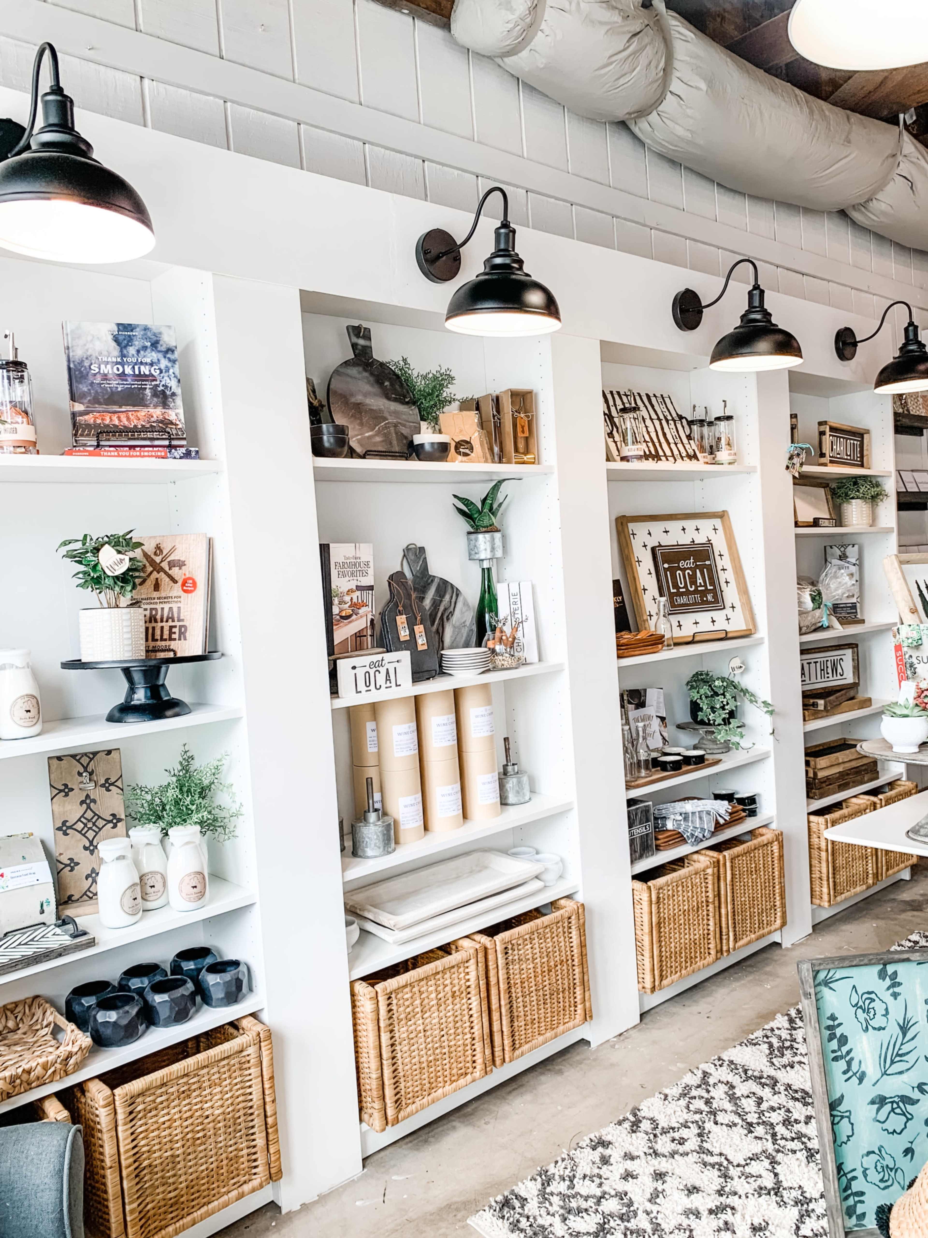A well-organized store display featuring shelves filled with various decorative items, books, and baskets.