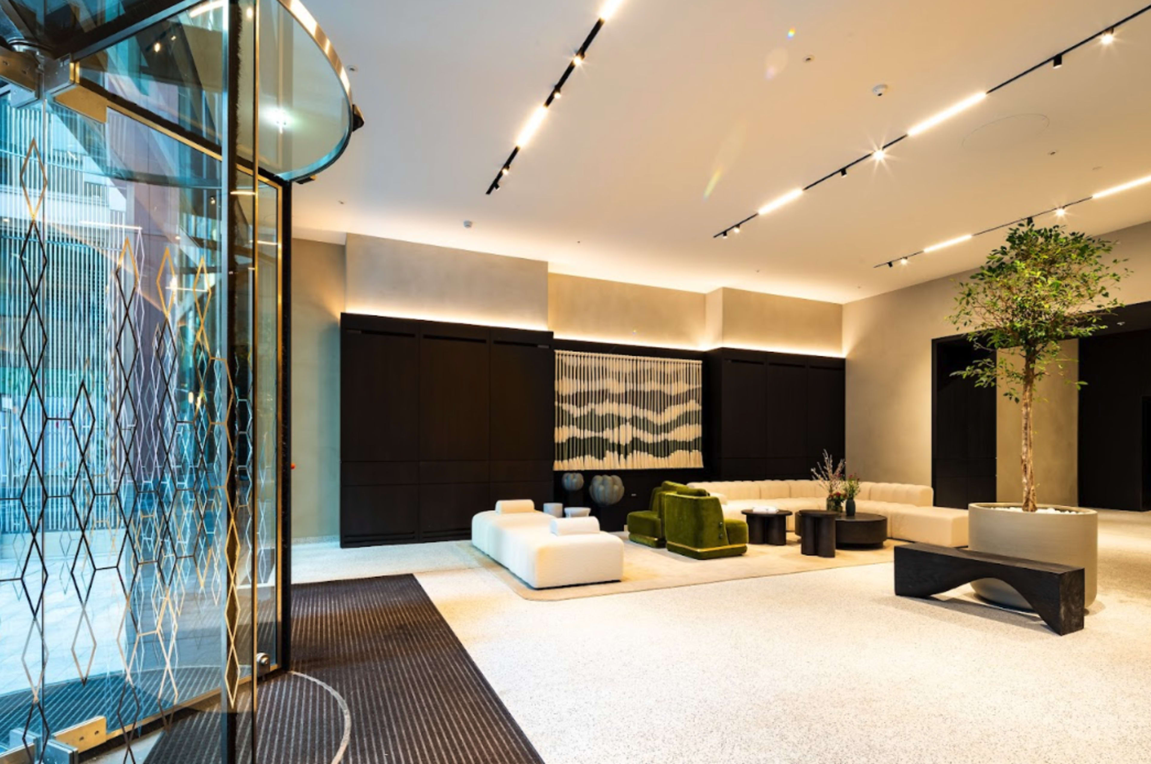 A modern lobby area with a reception desk, seating arrangements, and decorative elements like plants and wall art.