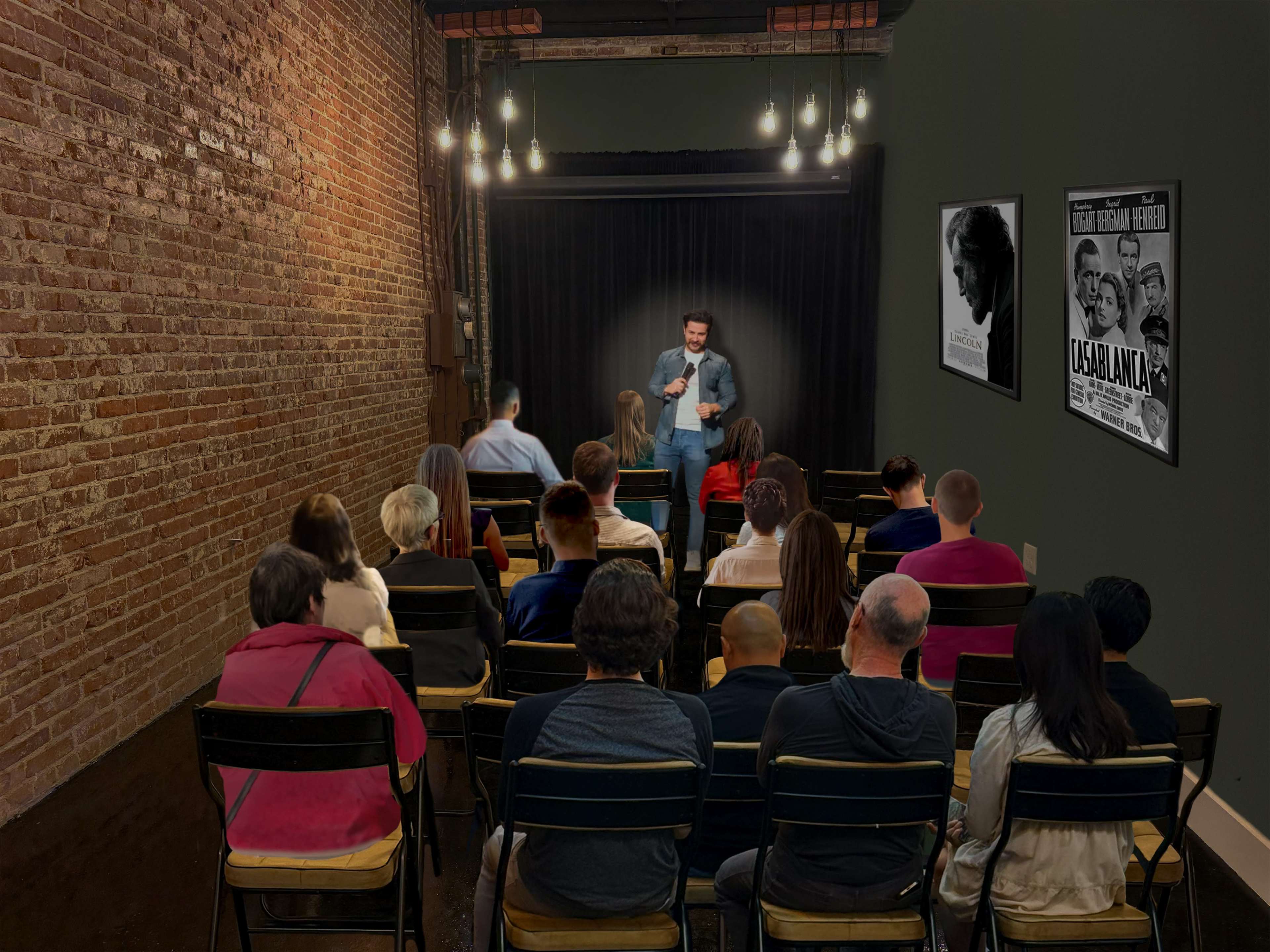 A comedian performs on stage in a small brick-walled venue while an audience sits in rows of chairs, facing him.