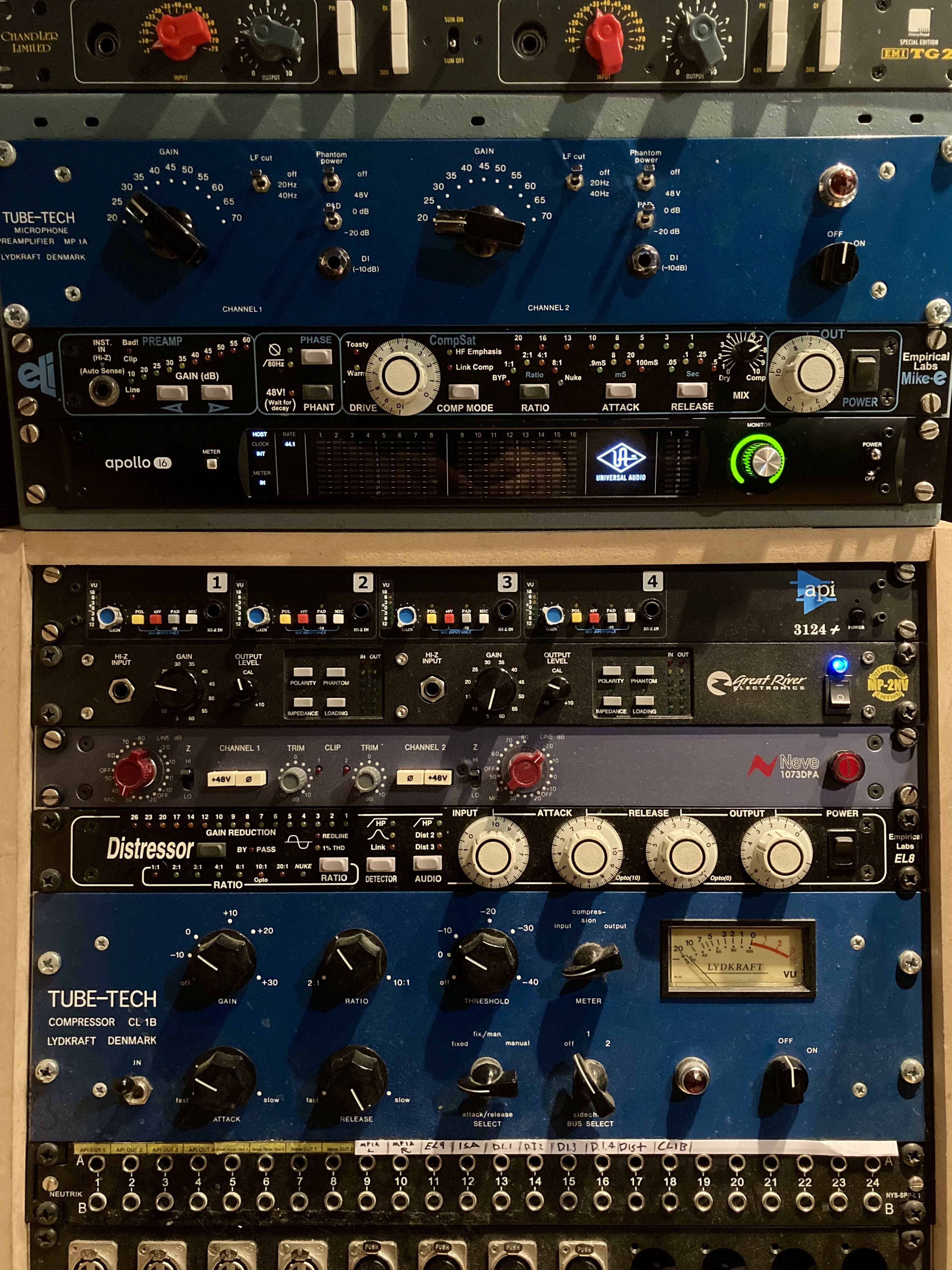 A stack of audio equipment featuring various audio processors and compressors, including Tube-Tech and Universal Audio devices.