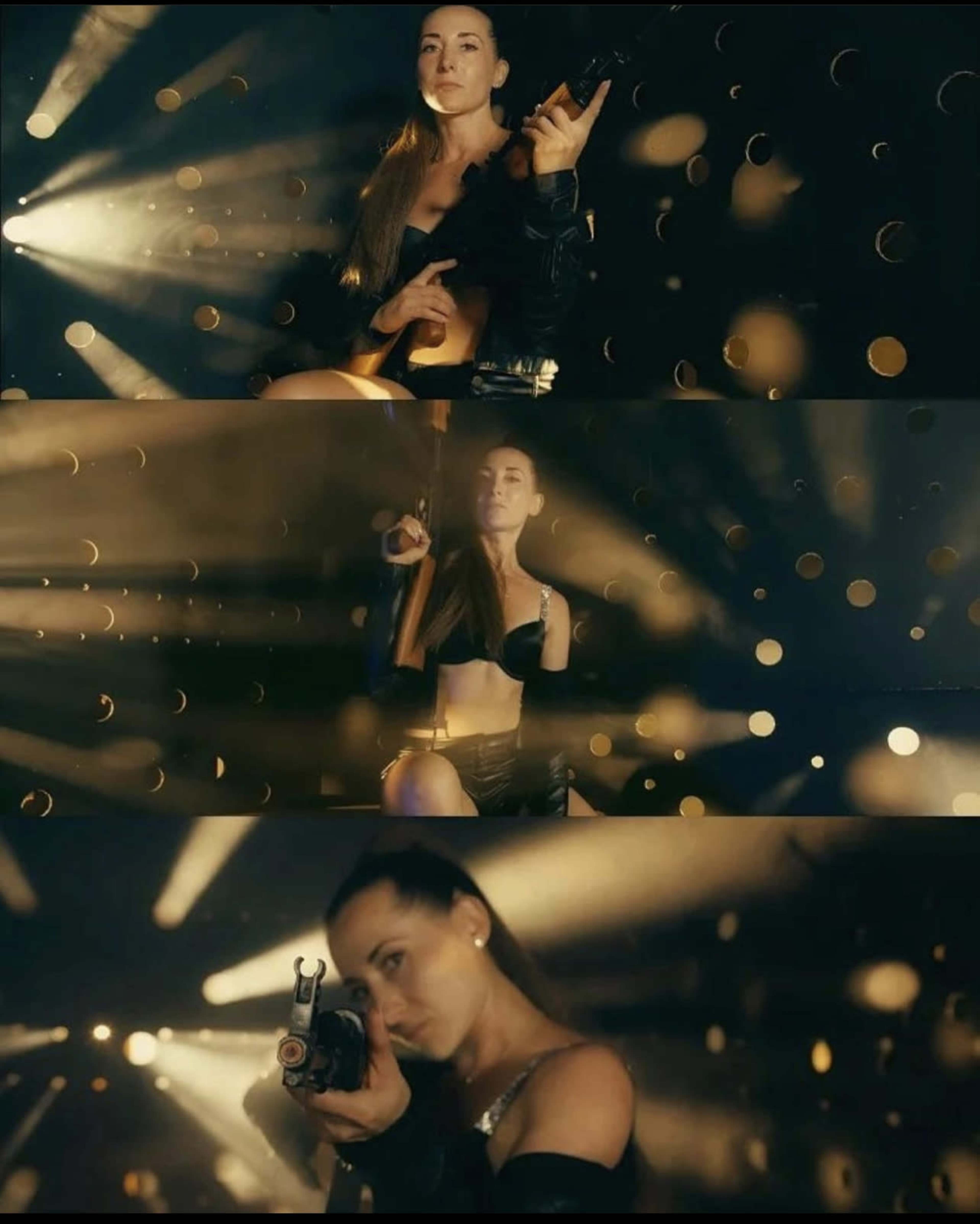 A woman holding a firearm poses confidently in a dimly lit setting with beams of light and floating particles around her.