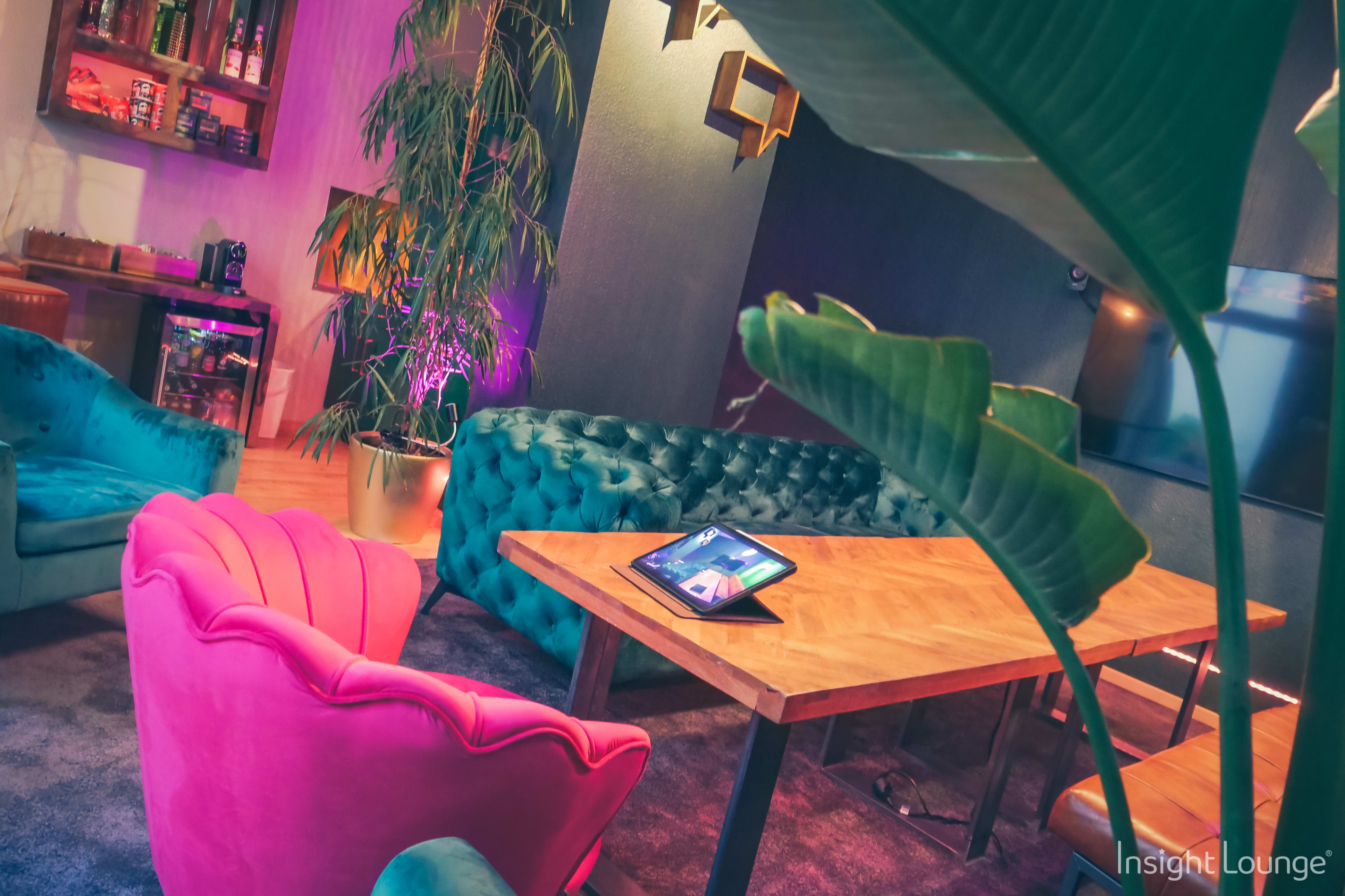 A cozy lounge area with colorful furniture, a wooden table, and a tablet placed on it.