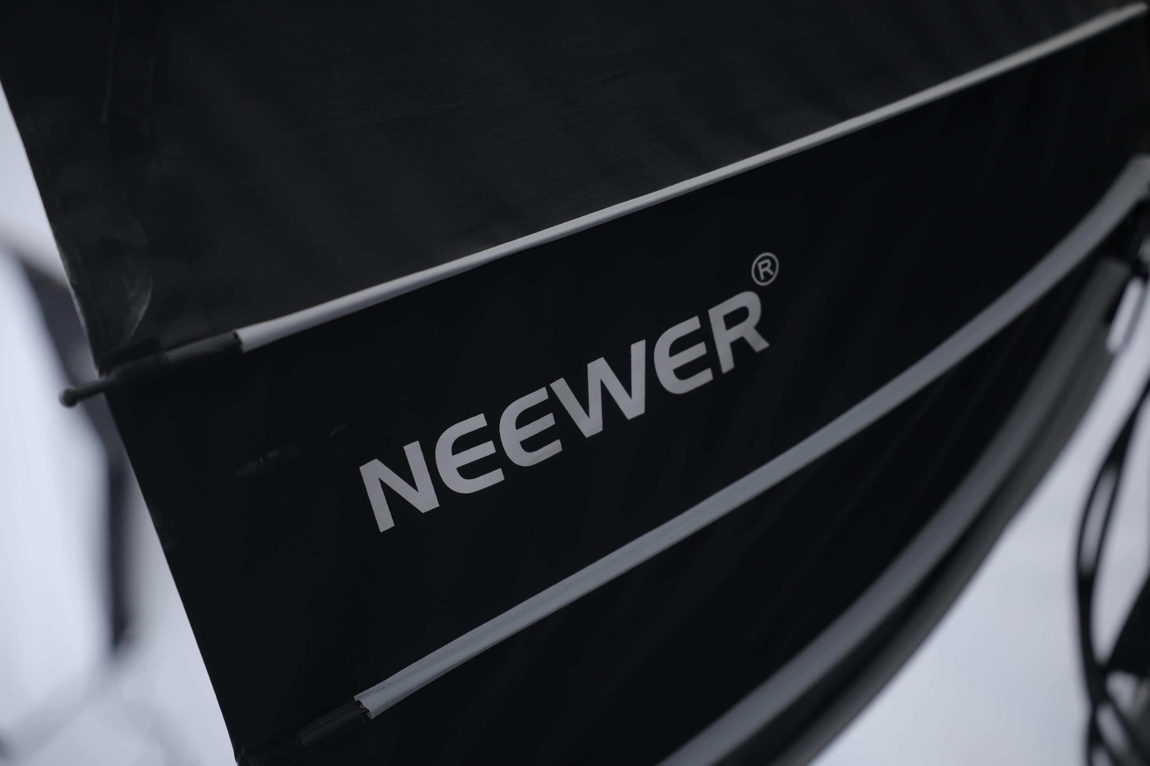 The image shows a close-up of a black fabric flag with the brand name "NEEWER" printed in white.