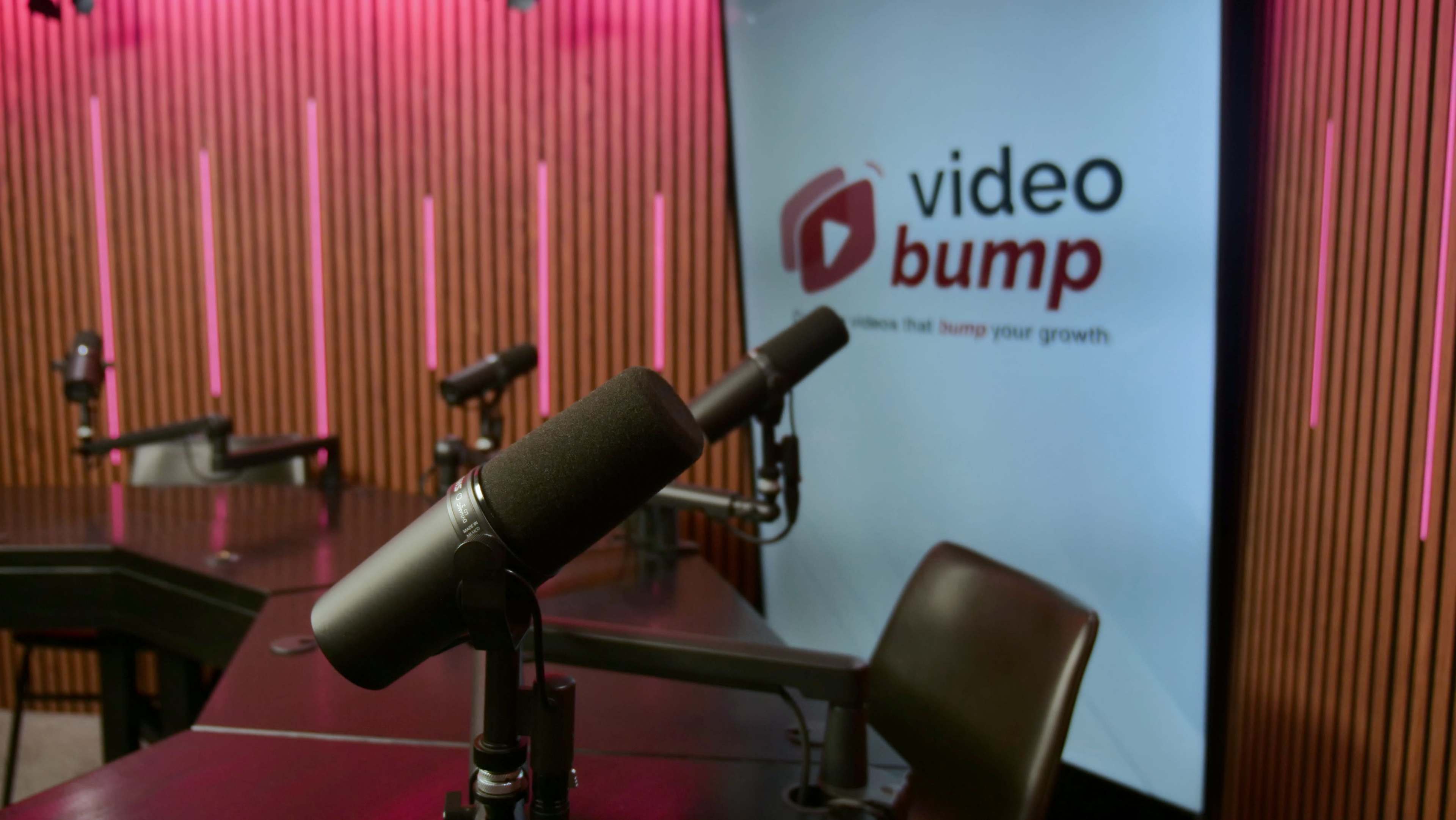 The image shows a recording studio with several microphones and a wall featuring the logo of "video bump."
