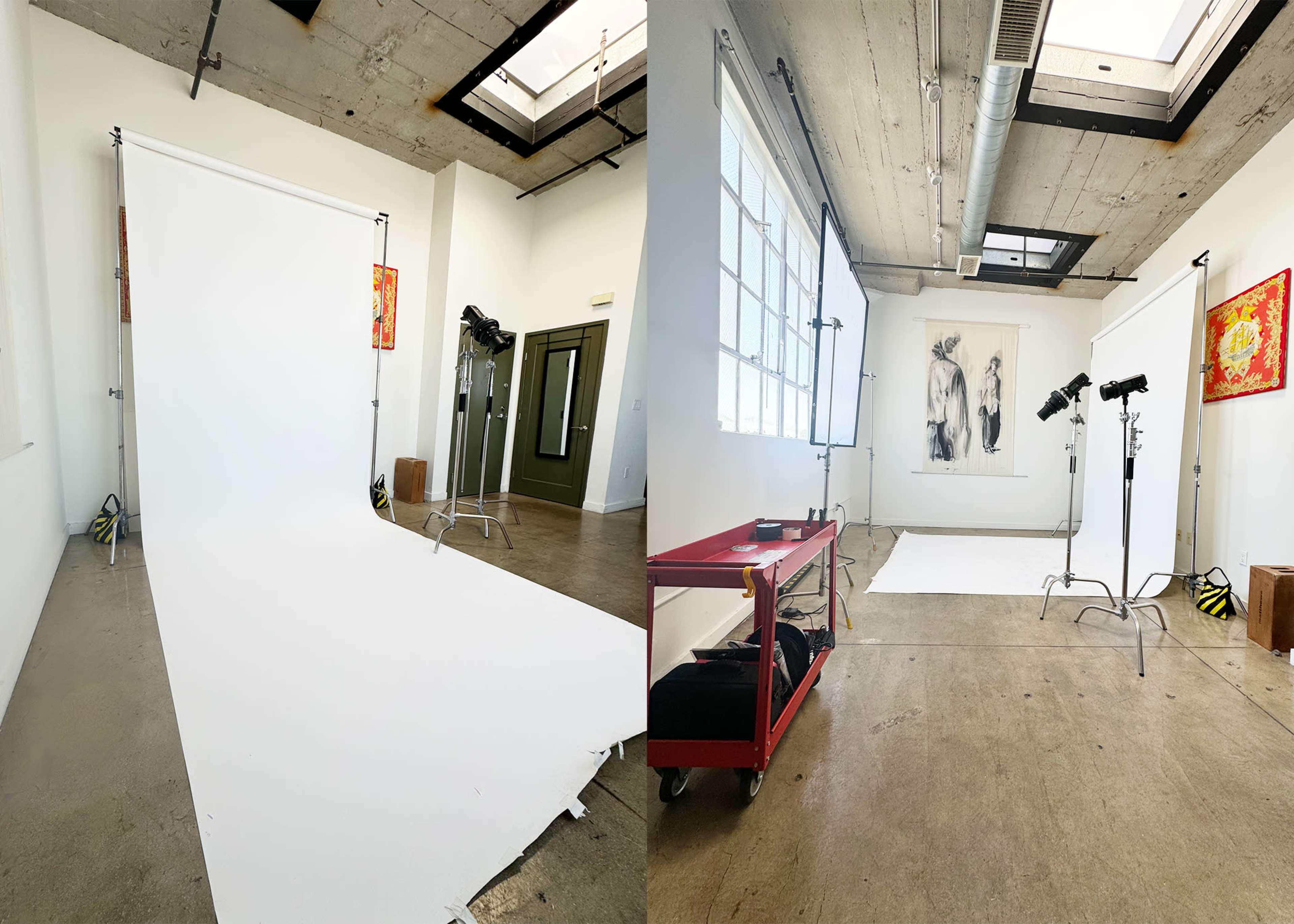 A photography studio with two white backdrops and lighting equipment set up in a room with industrial features.