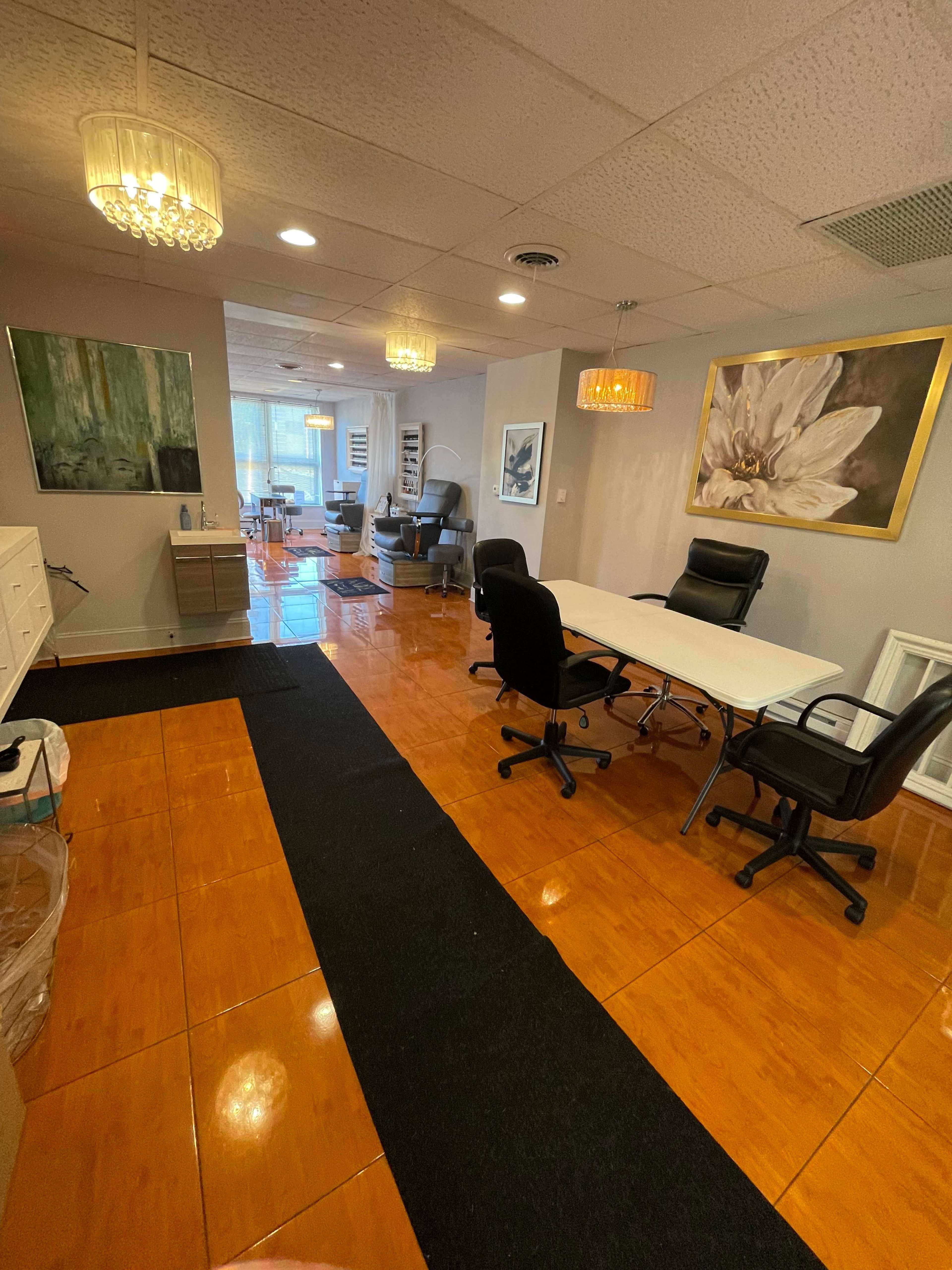 A brightly lit office space with a seating area, table, and decorative artwork on the walls.