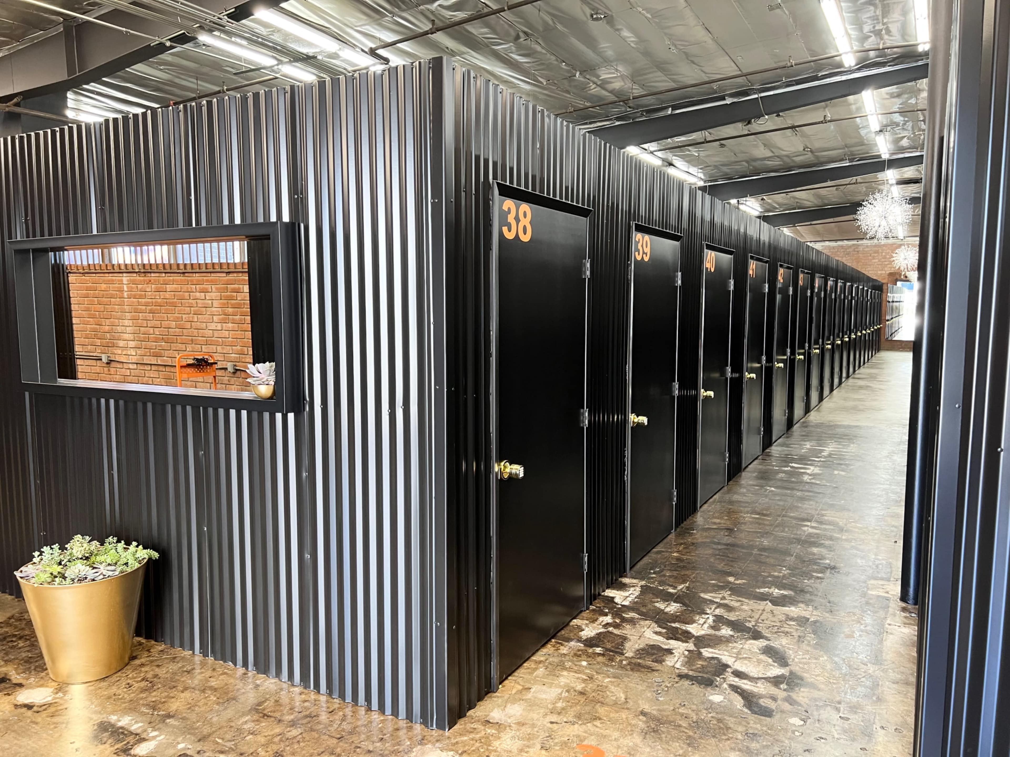 The image shows a row of metal storage units with doors numbered 38 and others, arranged in a well-lit, industrial space.