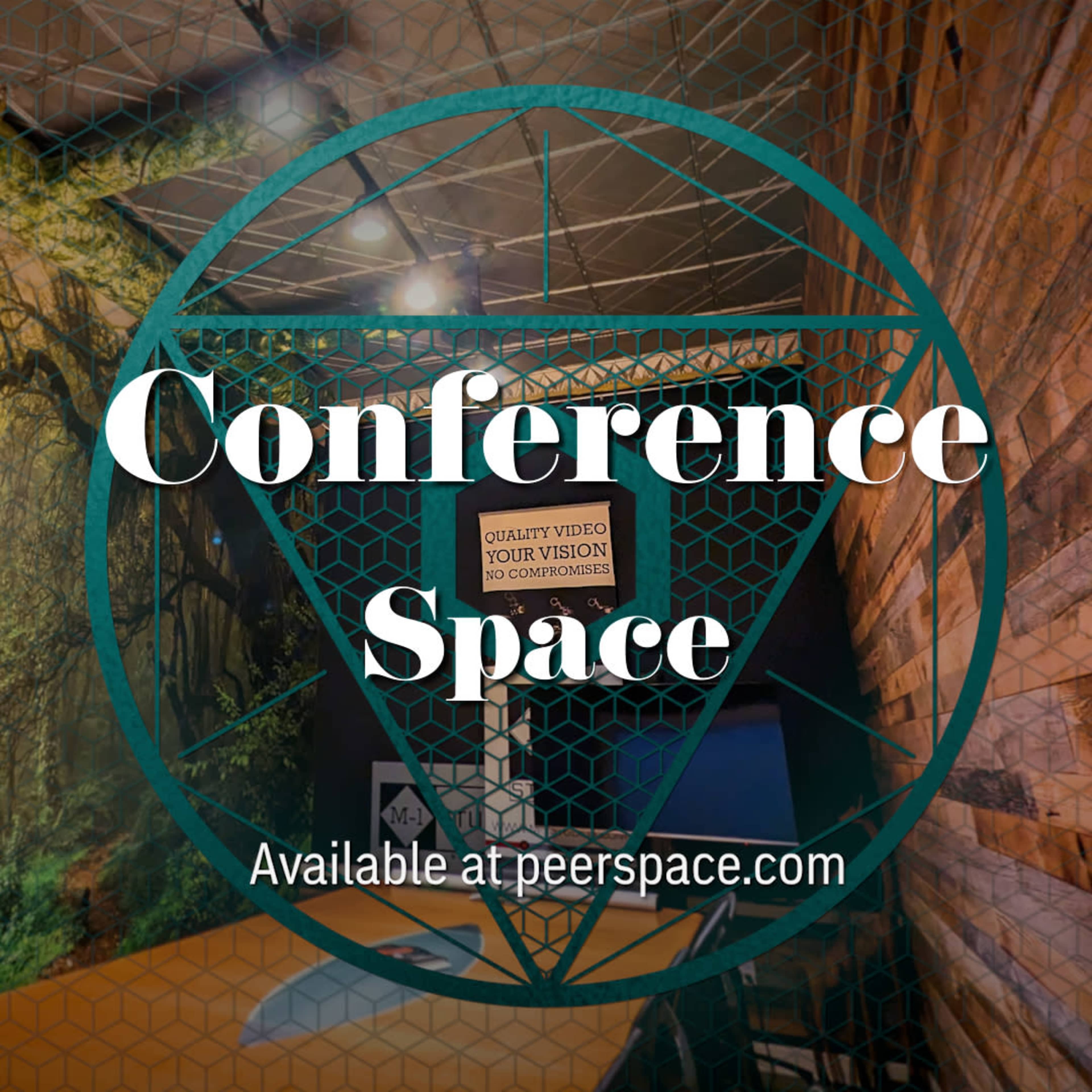 The image depicts a conference space with wooden walls and a green backdrop featuring trees.