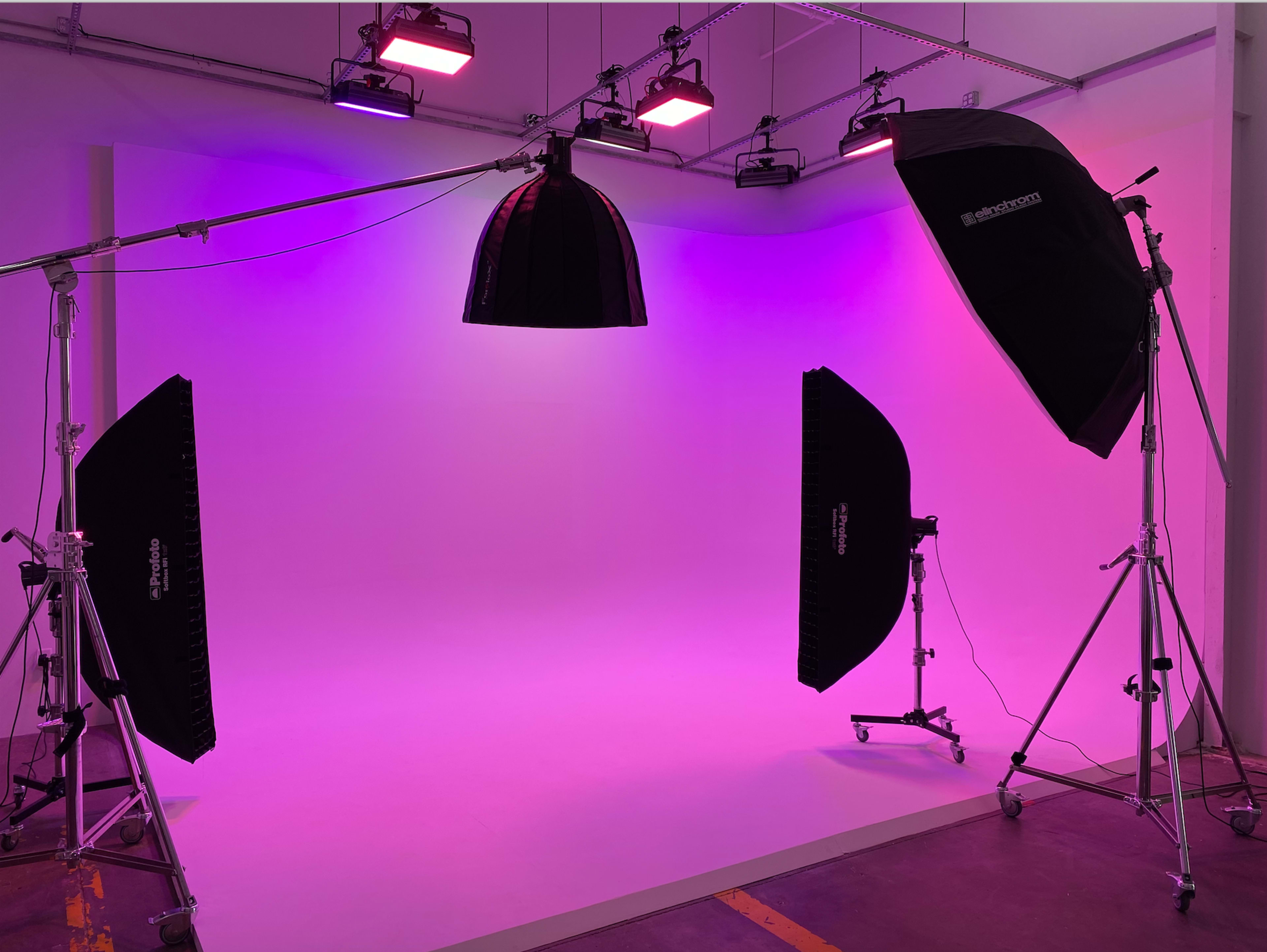 A photography studio setup with distinct lighting equipment and a gradient backdrop.