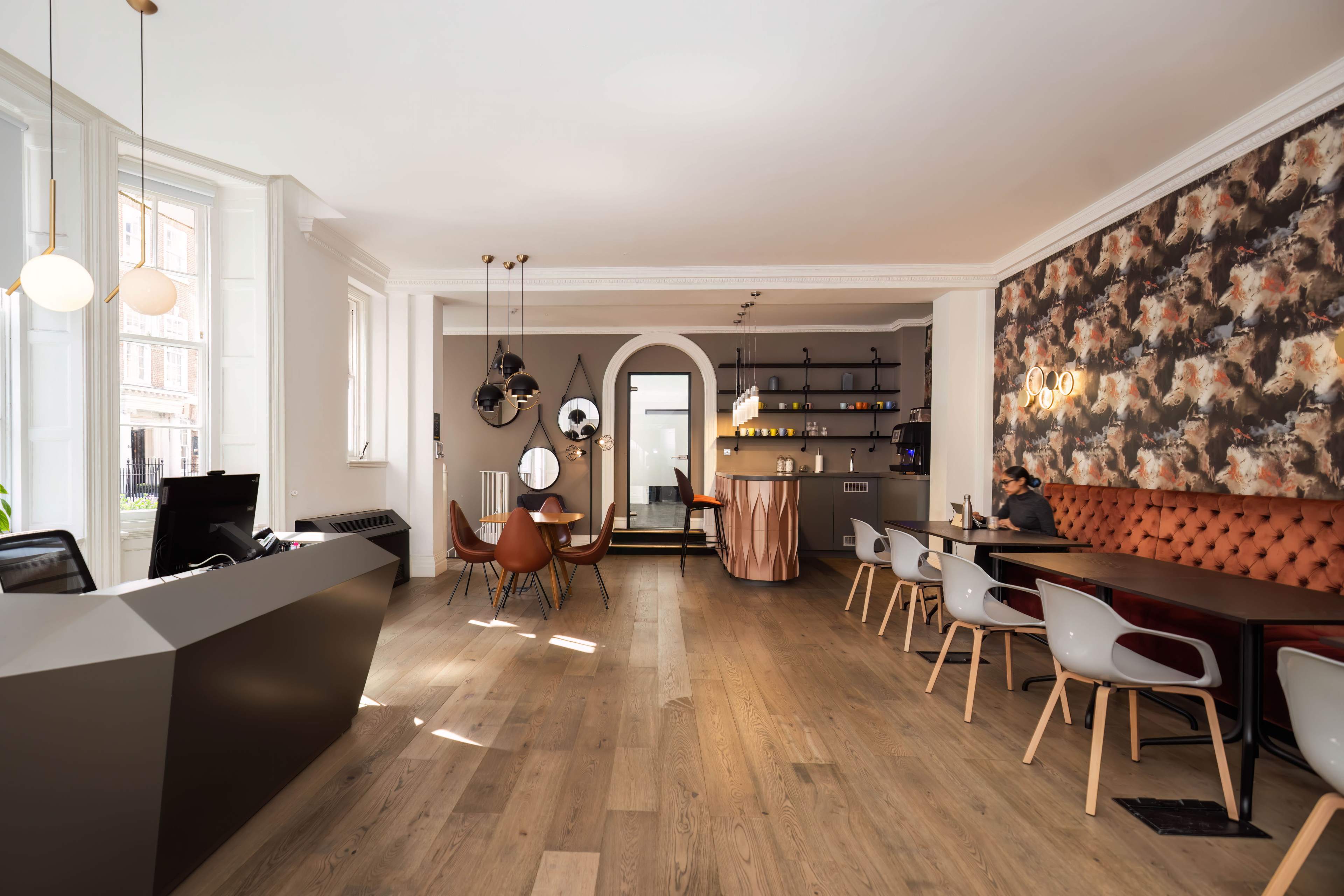 The scene features a modern reception area with a sleek front desk, stylish seating arrangements, and a floral accent wall, creating a welcoming environment.