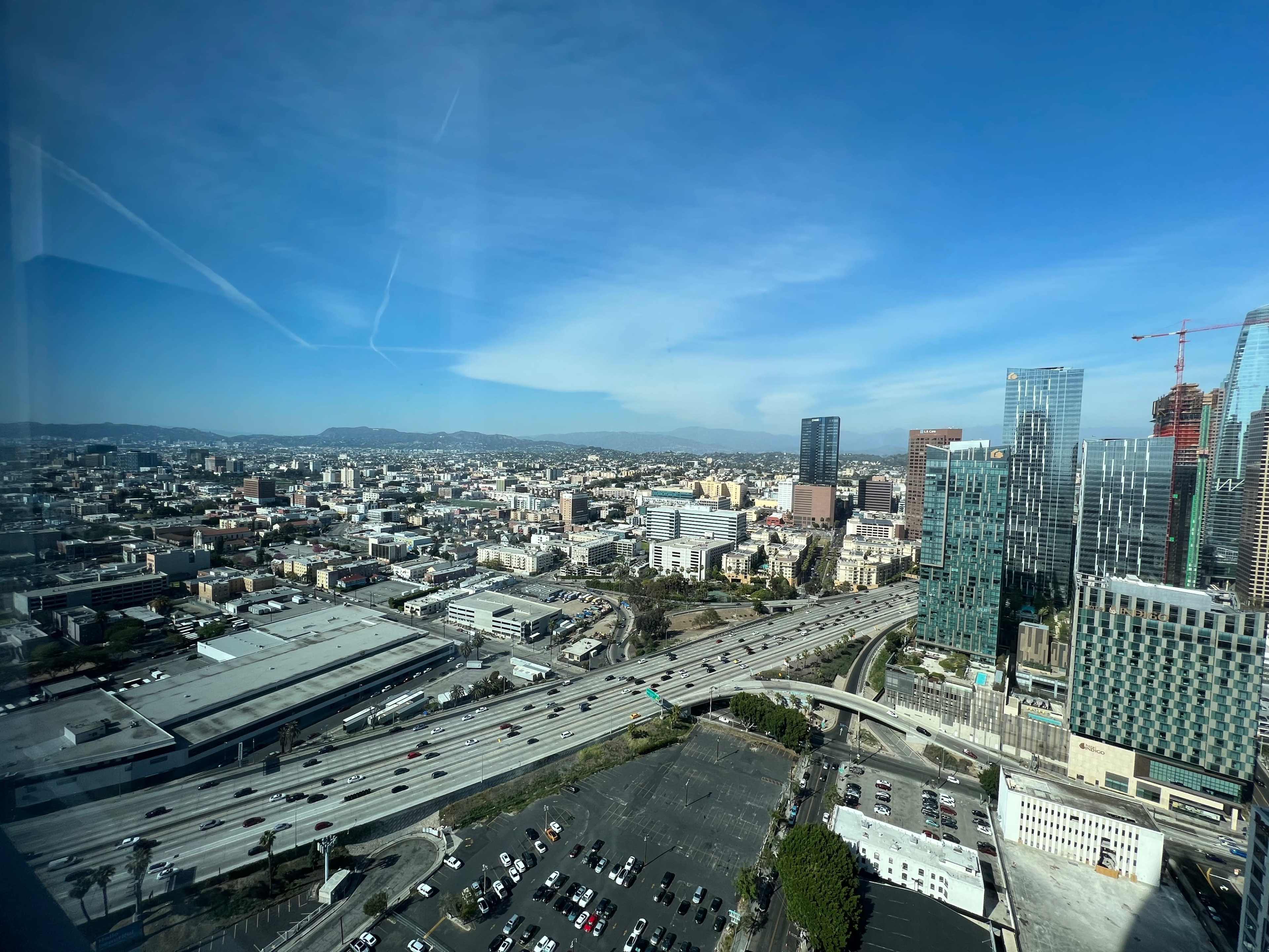A cityscape with a highway, buildings, and a clear blue sky.
