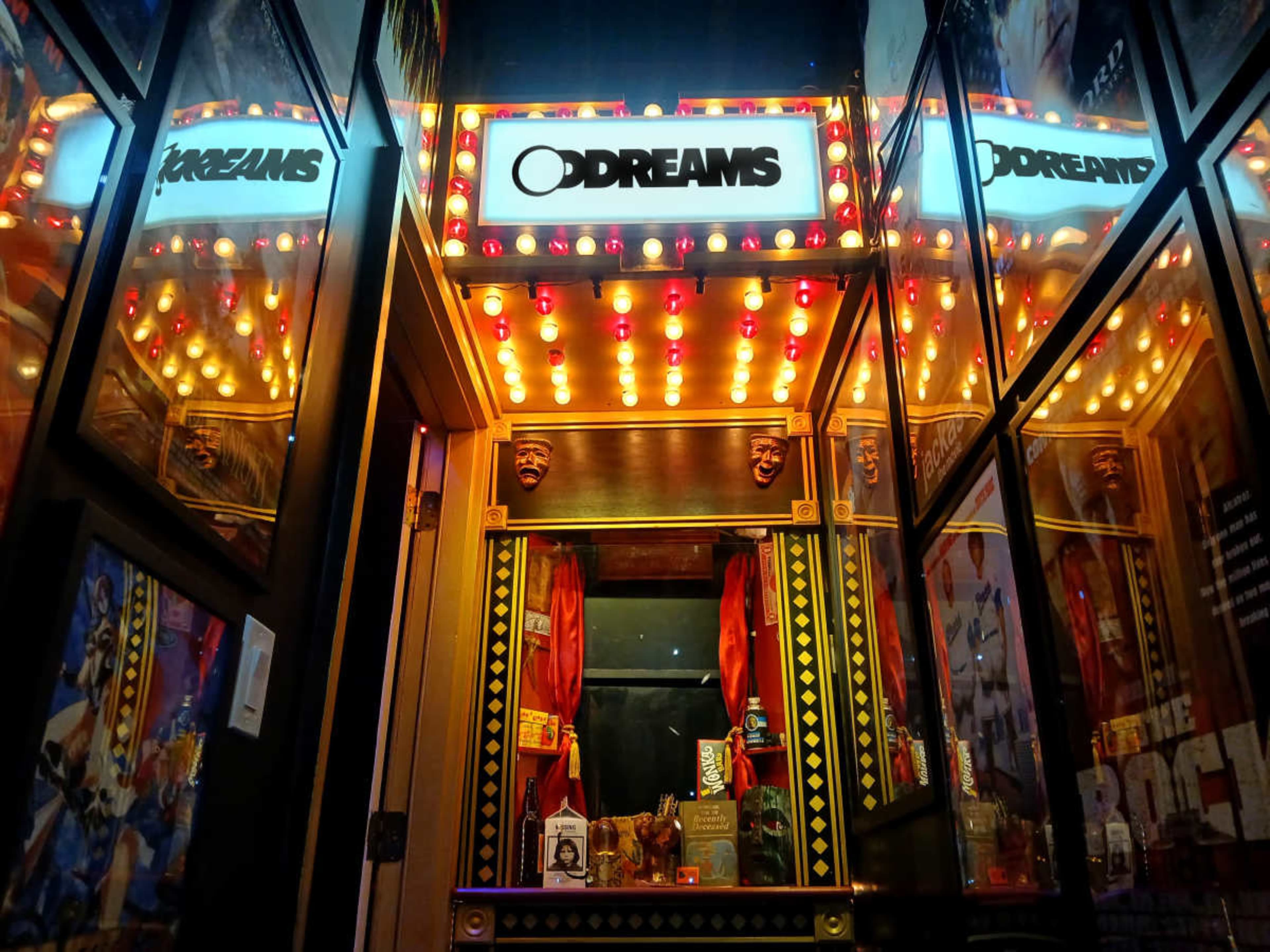 The image shows a brightly lit arcade-style booth titled "O Dreams," featuring an ornate display with mirrors and decorative elements.