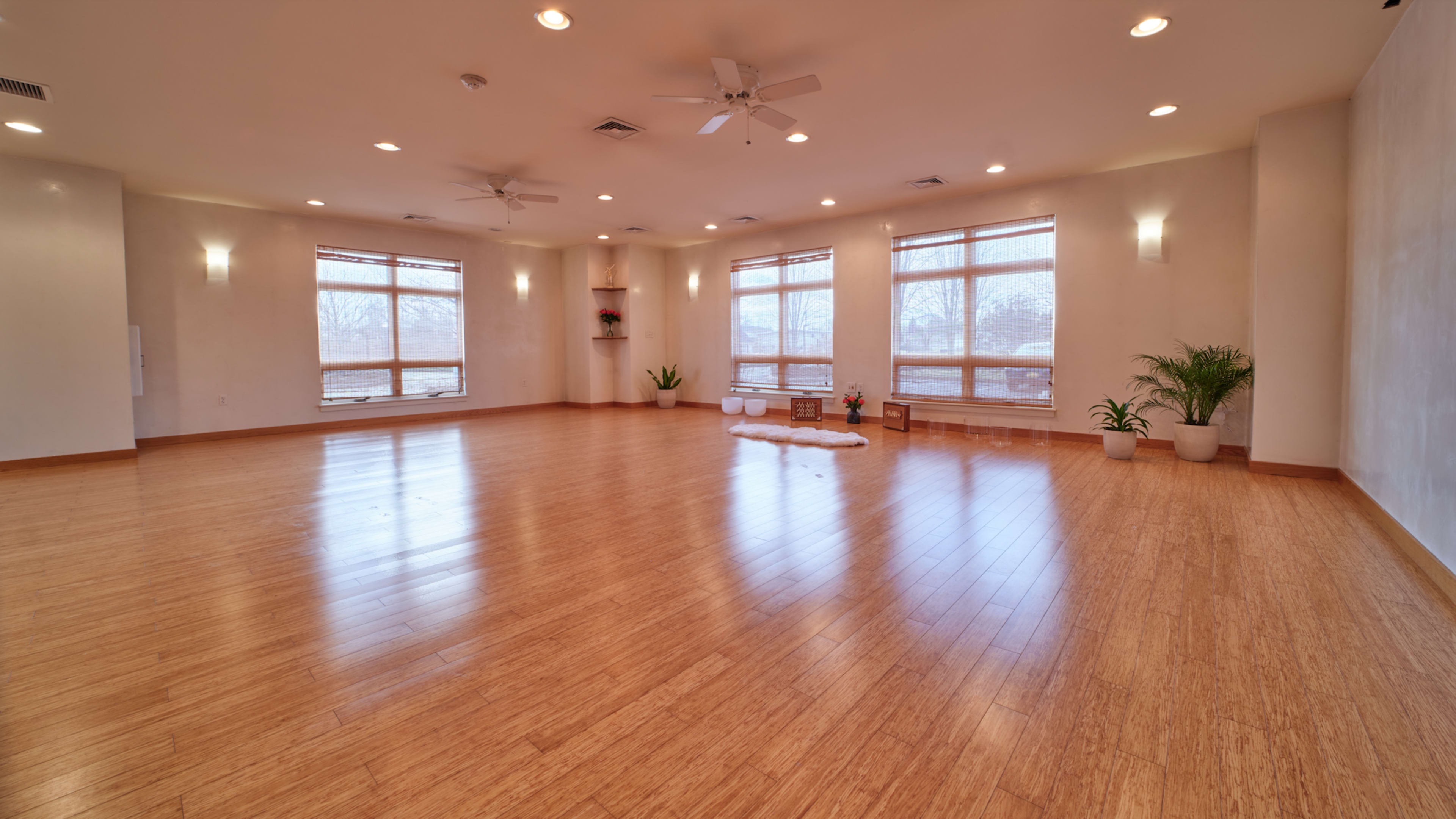 A spacious, well-lit room with bamboo flooring and large windows that provide natural light.