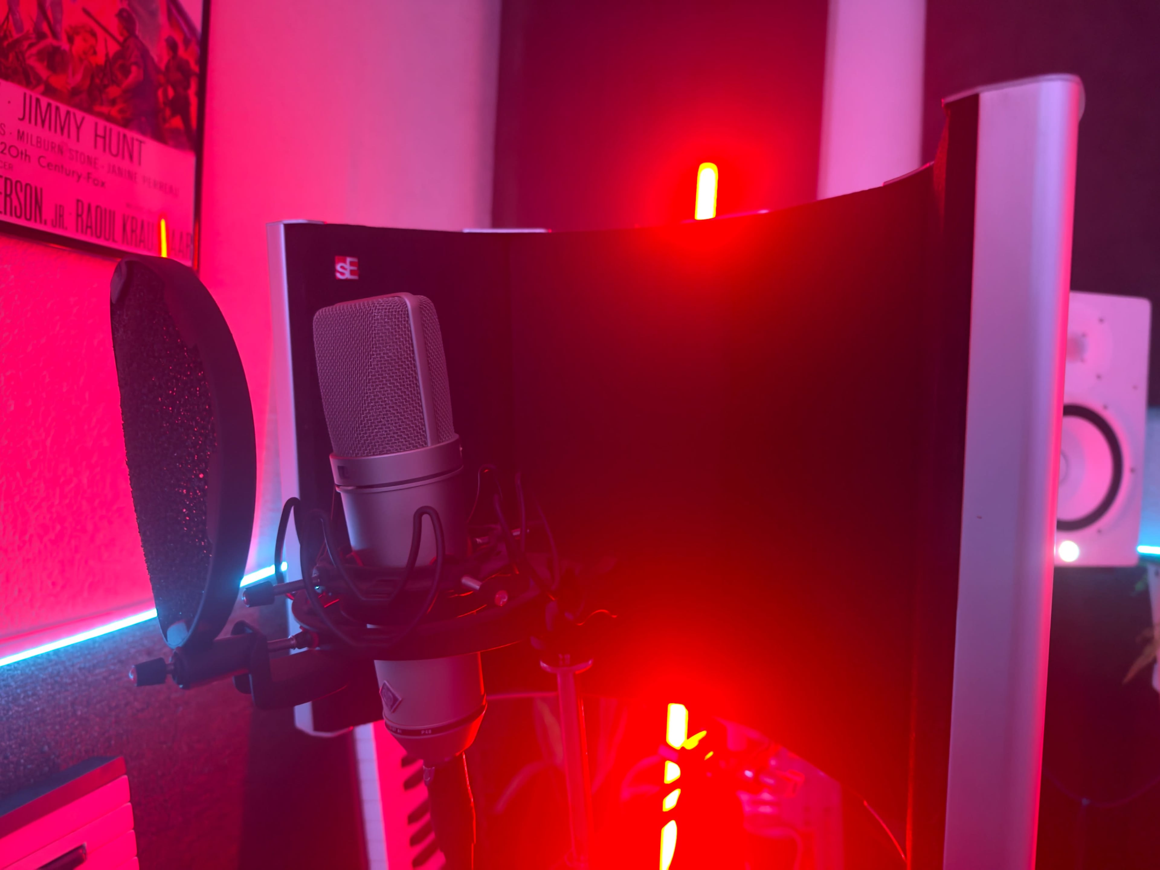 The image shows a microphone mounted in front of a curved reflection filter, with red lights illuminating the background.