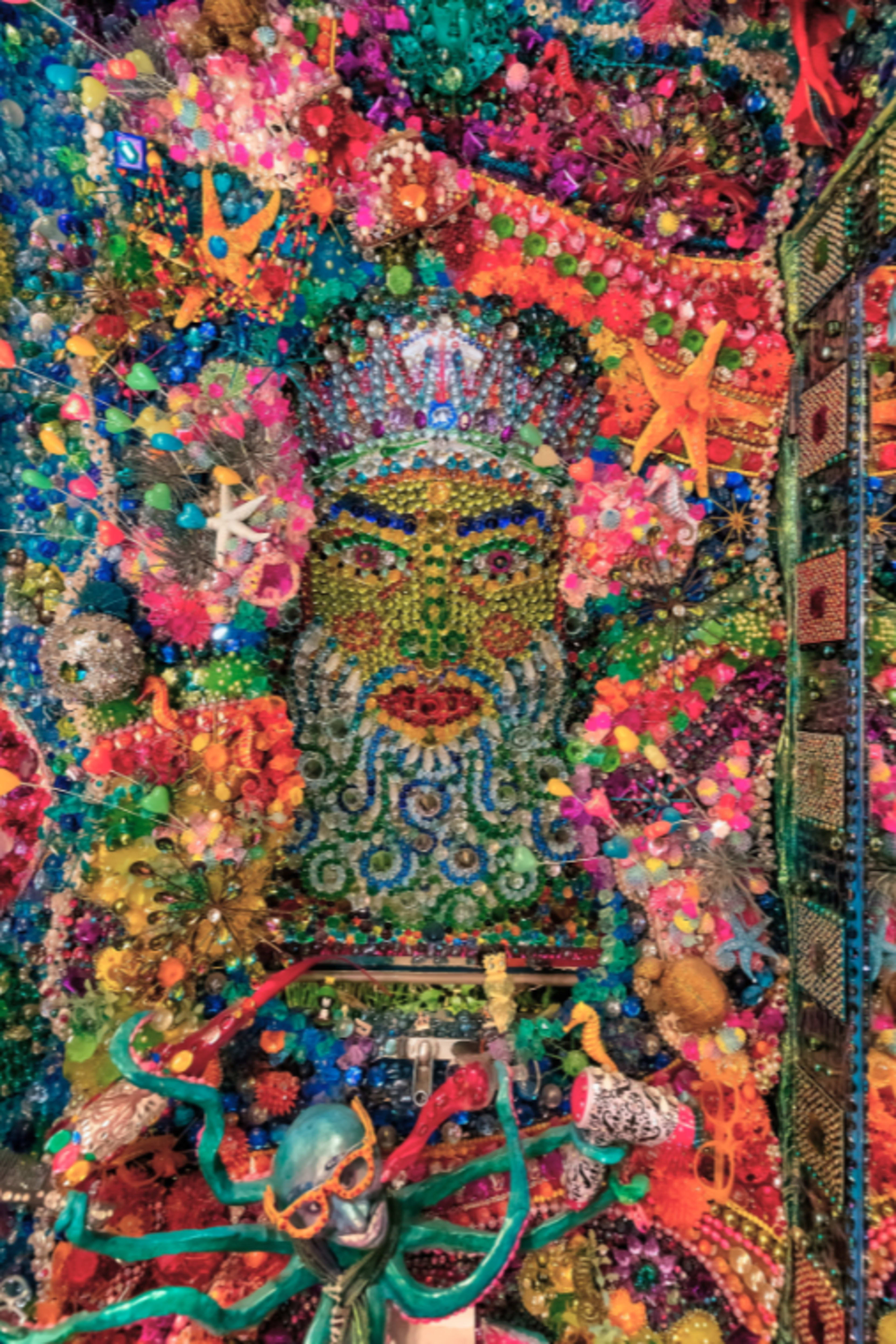 A vibrant, colorful mosaic depicting a bearded figure surrounded by various marine elements, including stars and an octopus.