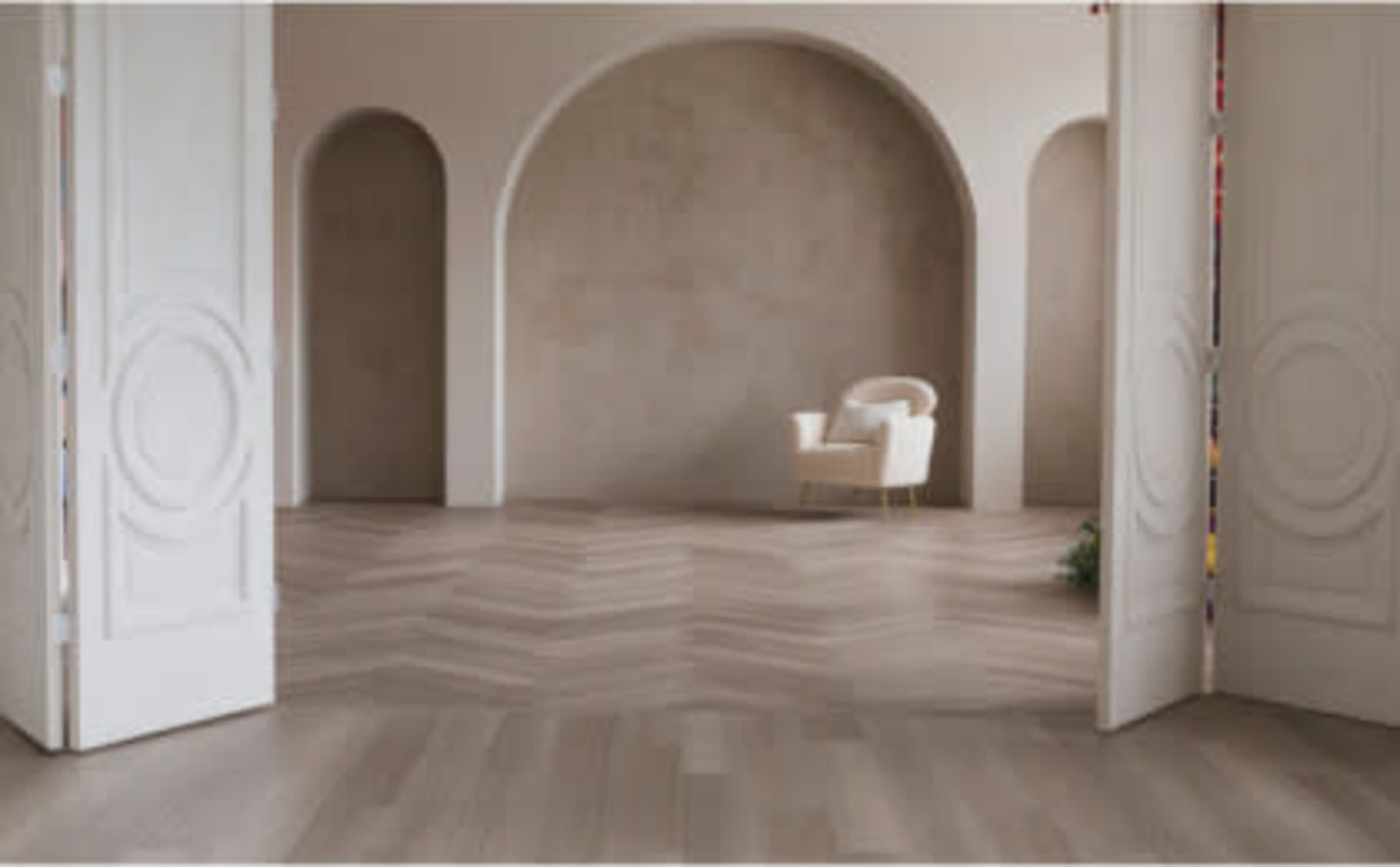 A spacious room features arched doorways, a light-colored chair, and herringbone-patterned flooring.