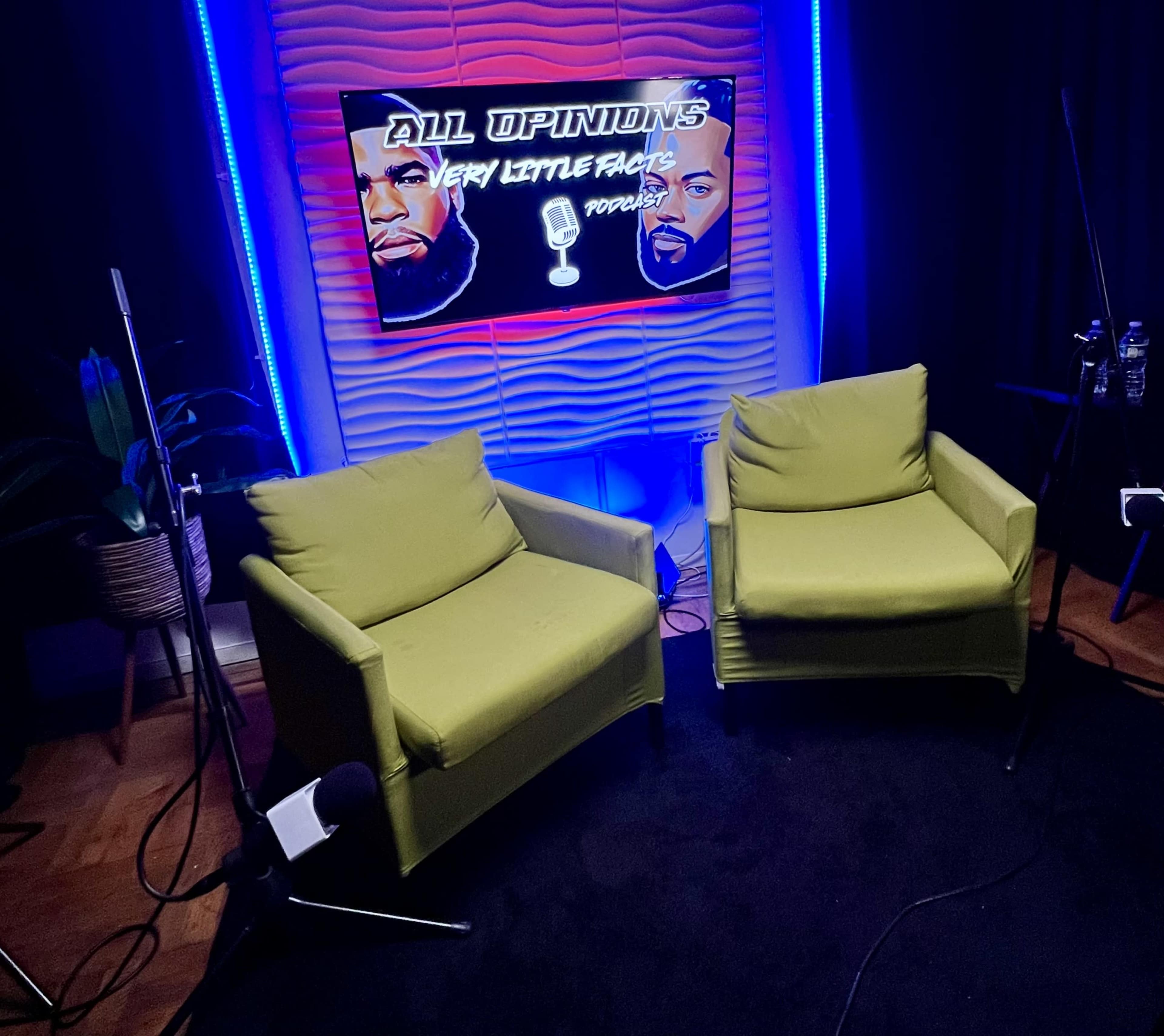 The image shows two green chairs facing each other in a podcast studio with a brightly lit background featuring the text "ALL OPINIONS VERY LITTLE FACTS PODCAST."