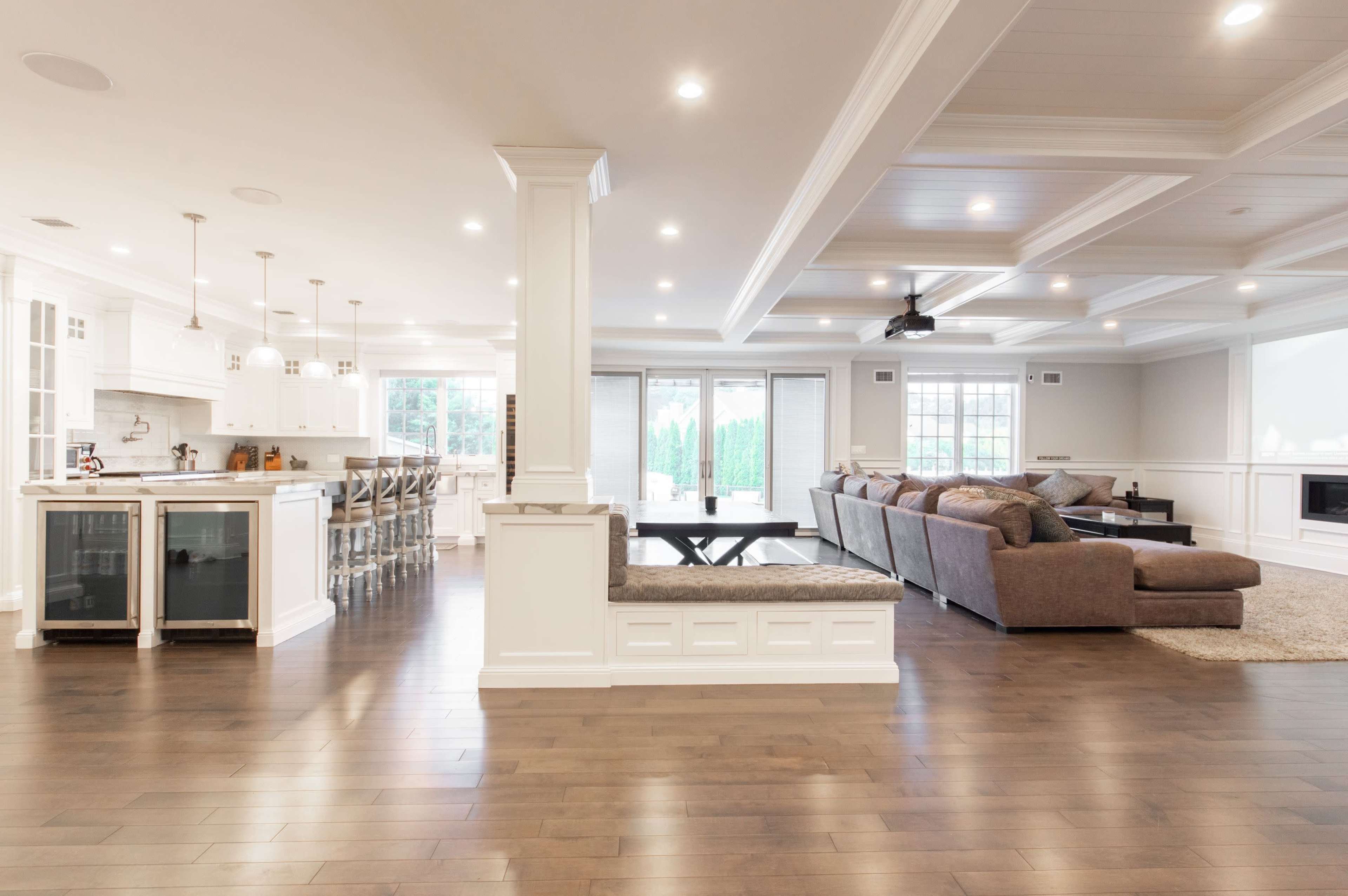 A spacious open-concept living area features a modern kitchen with a breakfast bar and a comfortable seating arrangement in the adjacent living room.