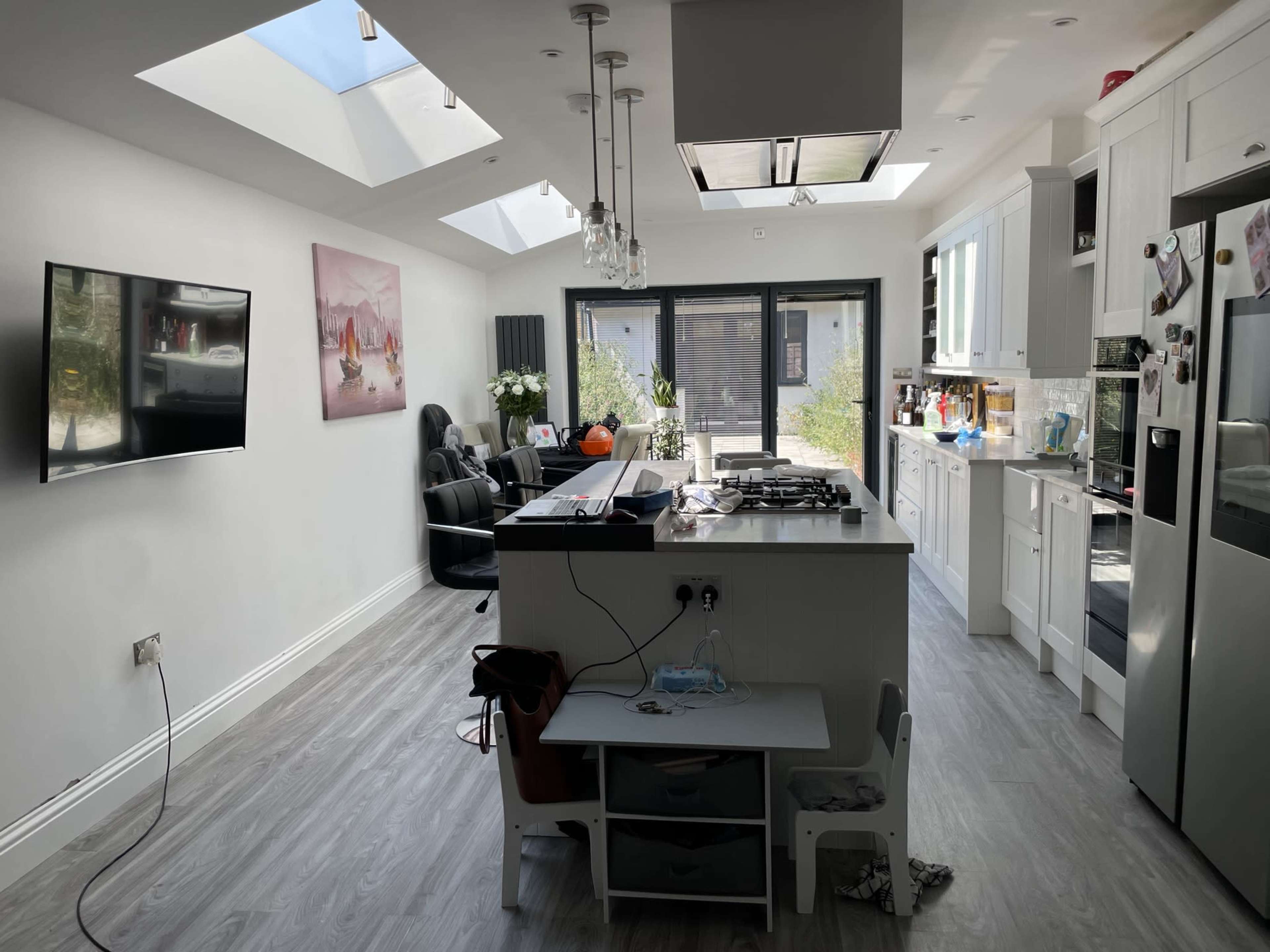 A bright kitchen and living area features modern appliances, a central island, and large windows flooding the space with natural light.
