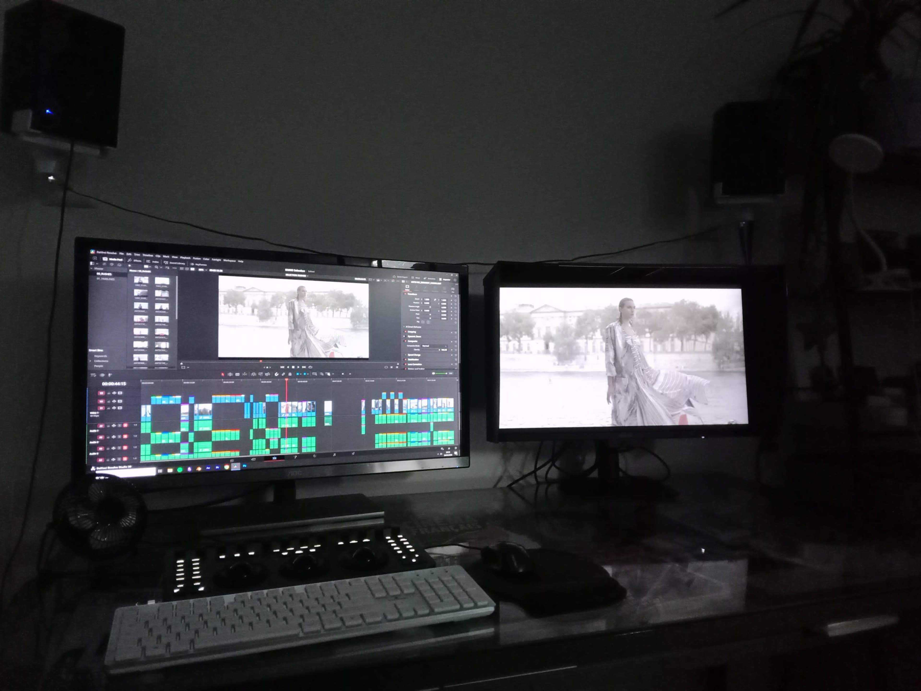 The image shows a dual-monitor computer setup used for video editing, with one screen displaying an editing software interface and the other screen showing a scene from a black-and-white film.