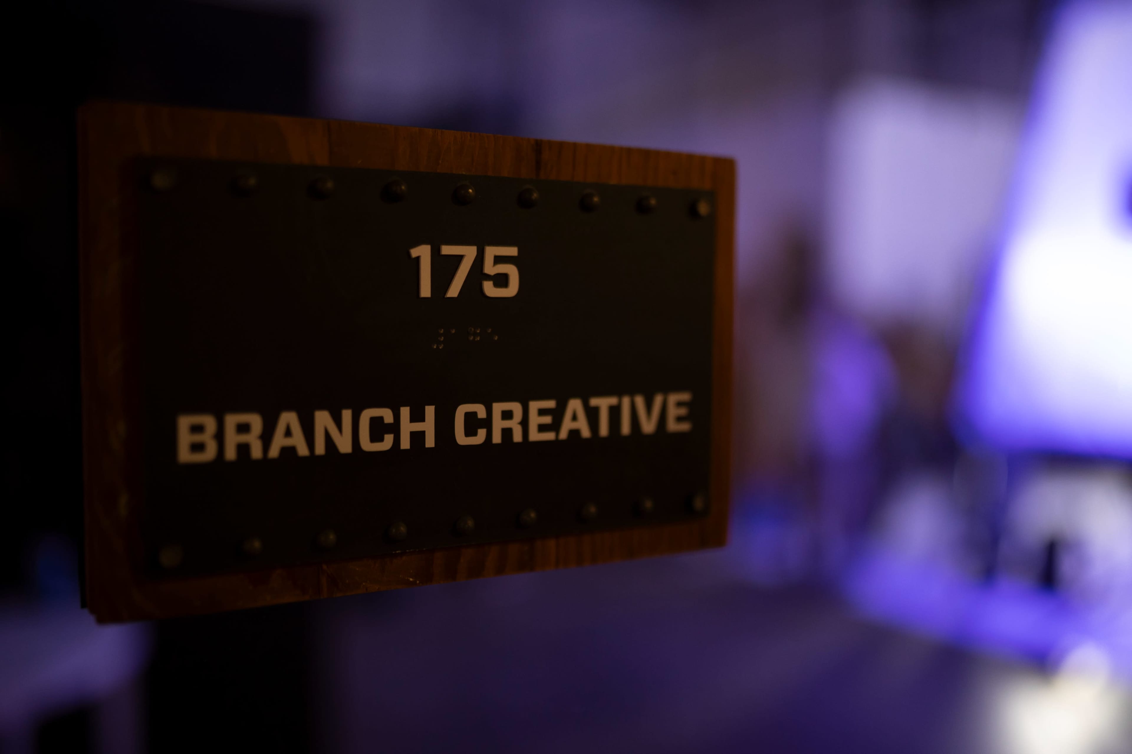 A wooden sign displaying the number "175" and the words "BRANCH CREATIVE" is mounted on a wall.
