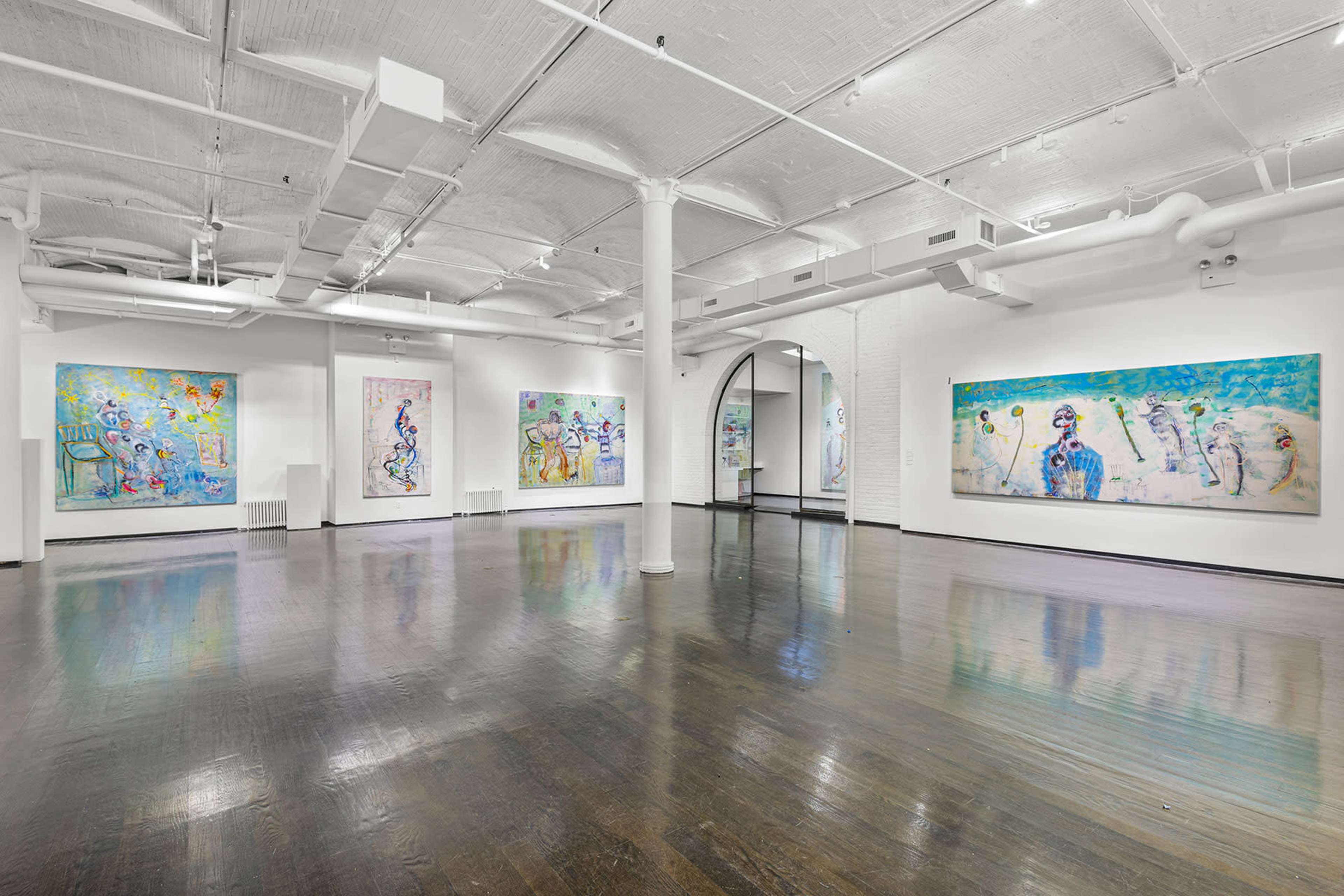 A spacious art gallery featuring several large, colorful paintings on the white walls and polished wooden floors reflecting the artwork.