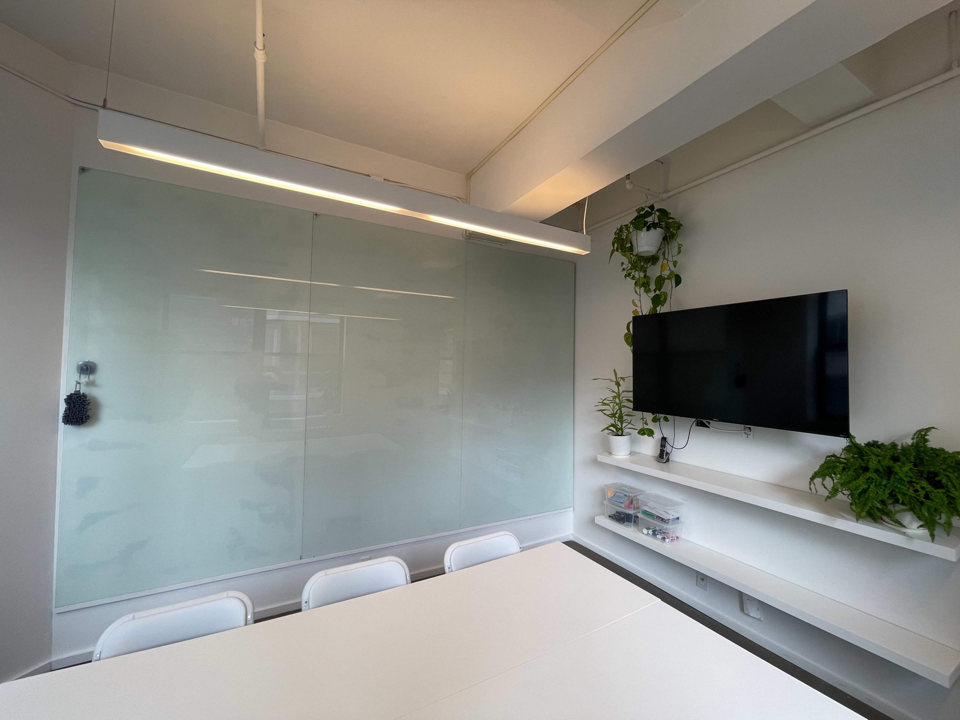 Light filled large meeting room with floor-to-ceiling white boards Image in Midtown Manhattan, New York, NY