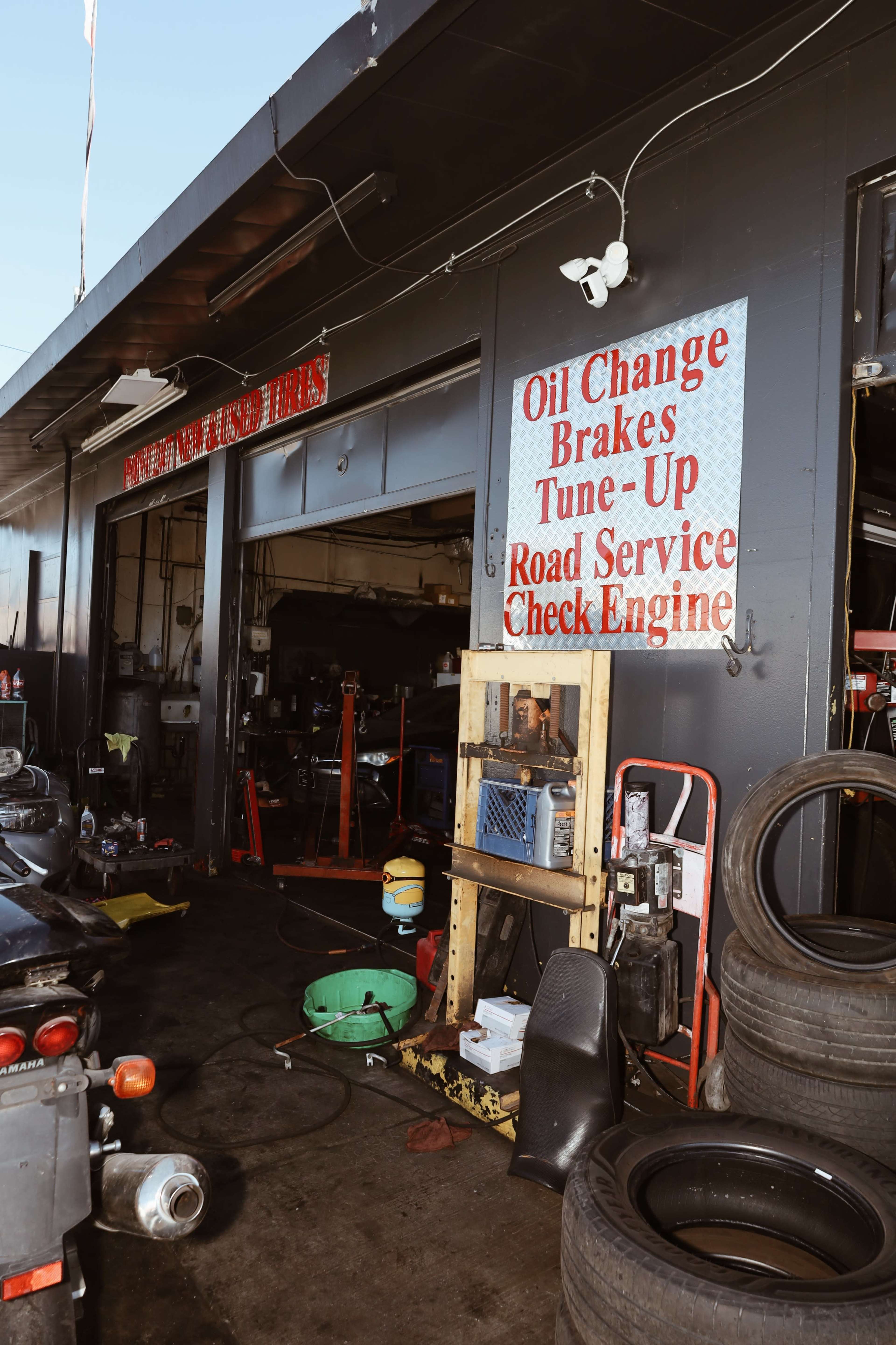 The image shows the entrance of an auto repair shop with signs advertising services like oil changes, brakes, and tune-ups.