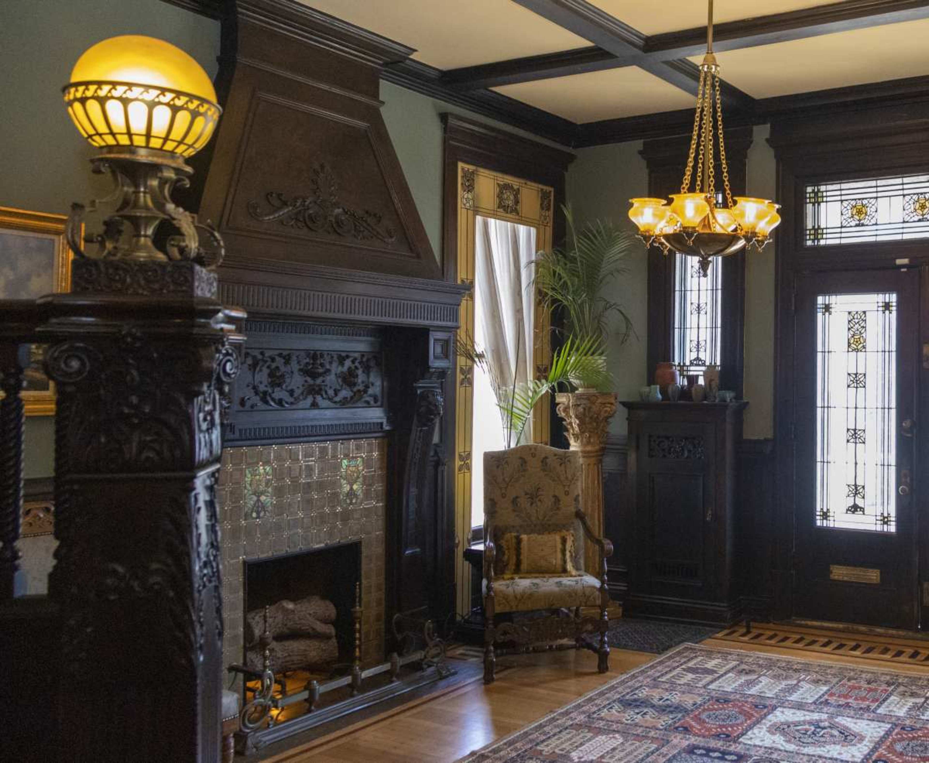 The image shows a richly decorated room featuring a large fireplace, ornate furnishings, and intricate architectural details.
