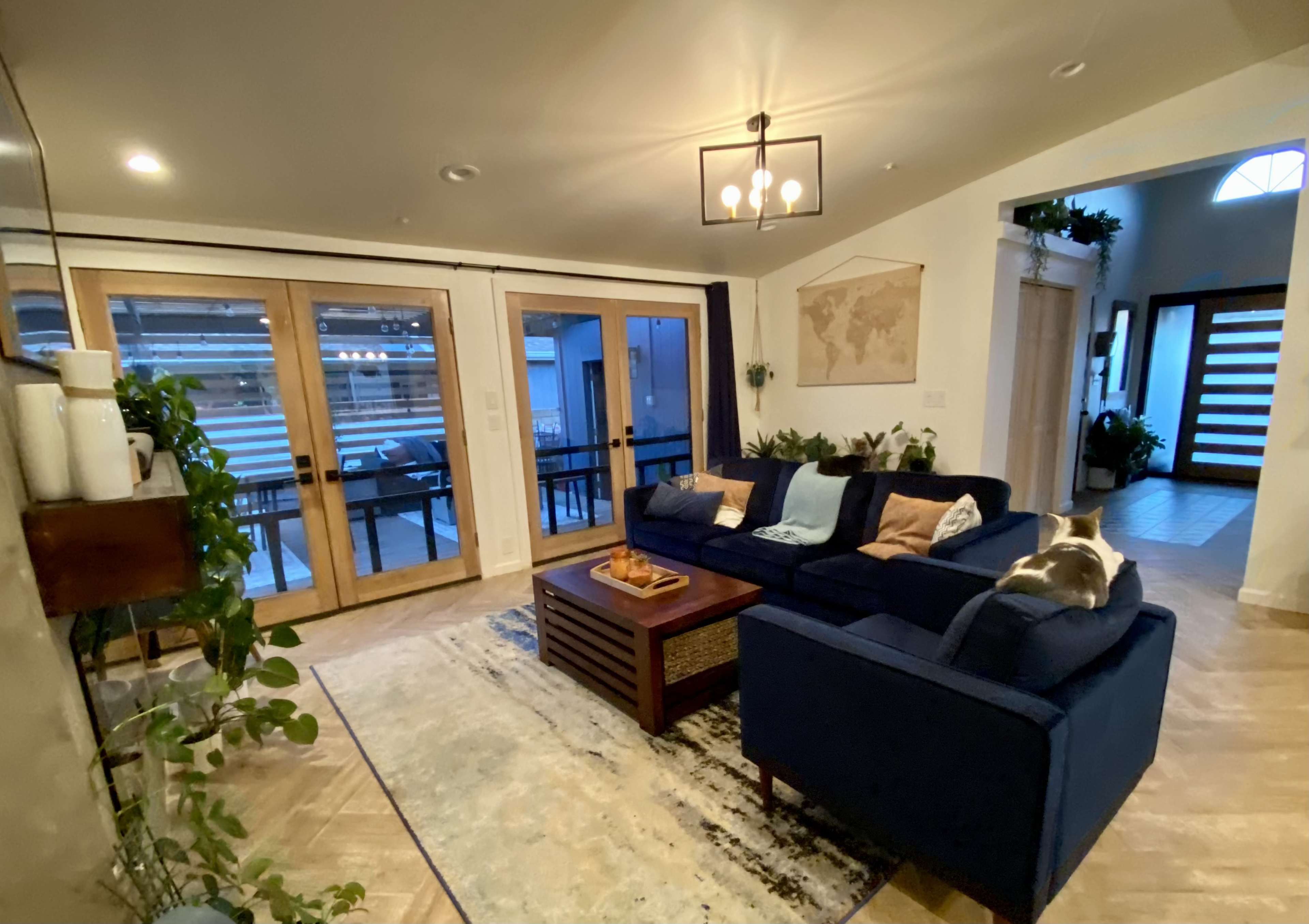 A living room with a blue couch, a wooden coffee table, and large glass doors leading to an outdoor area.