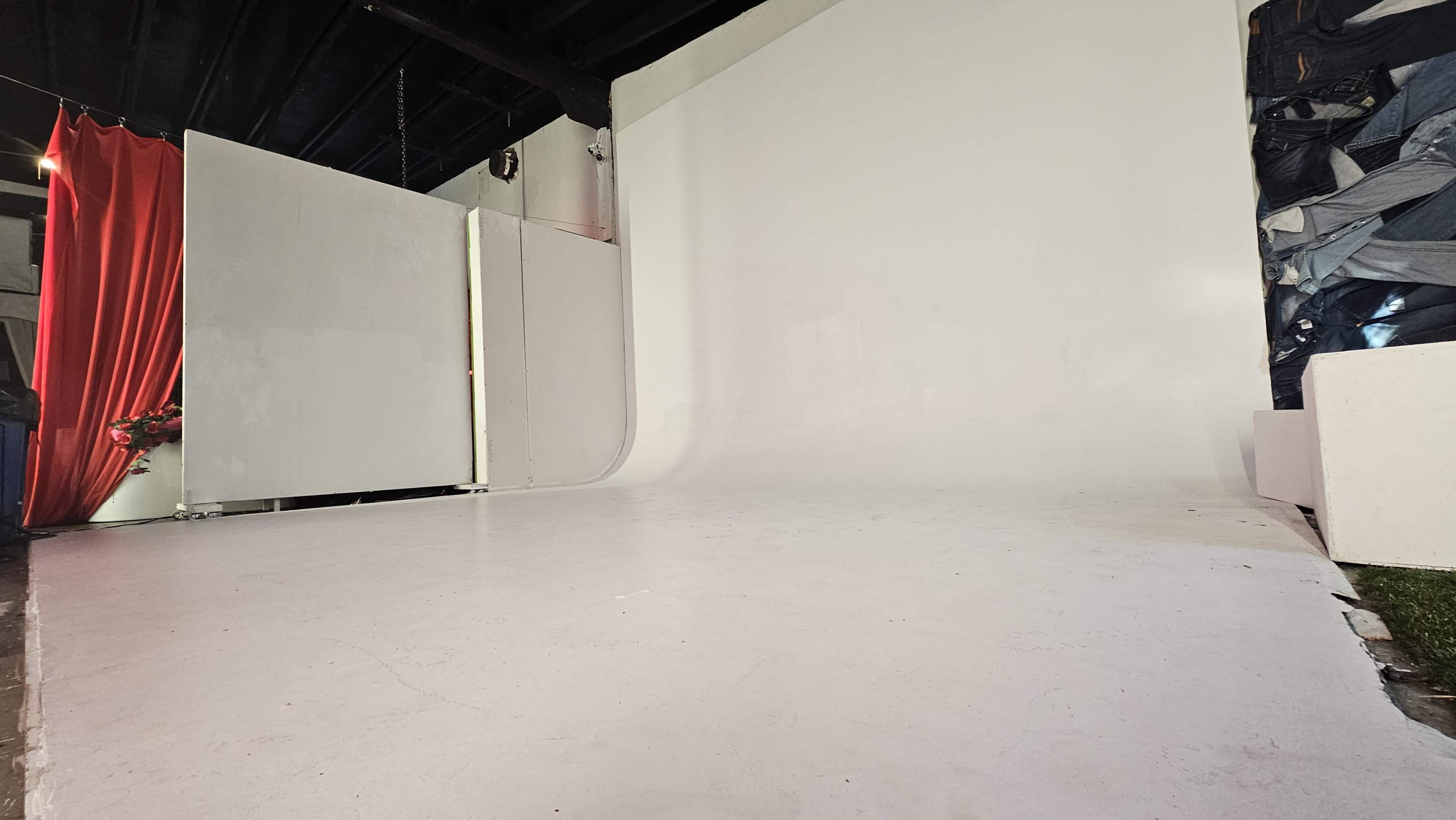 A spacious studio with a smooth white backdrop and several partition panels.