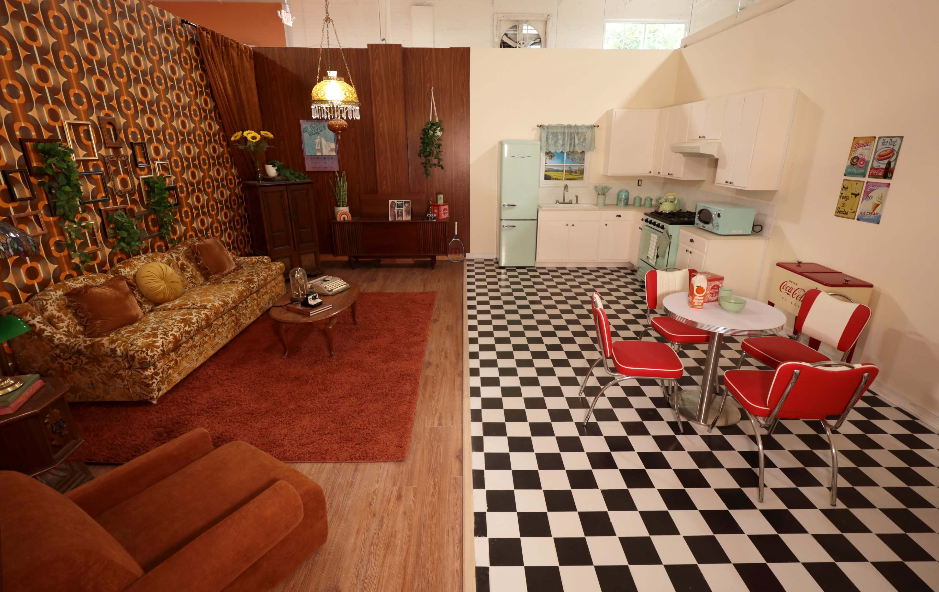 A retro-styled interior featuring a living room with a patterned sofa and a dining area with a checkered floor.