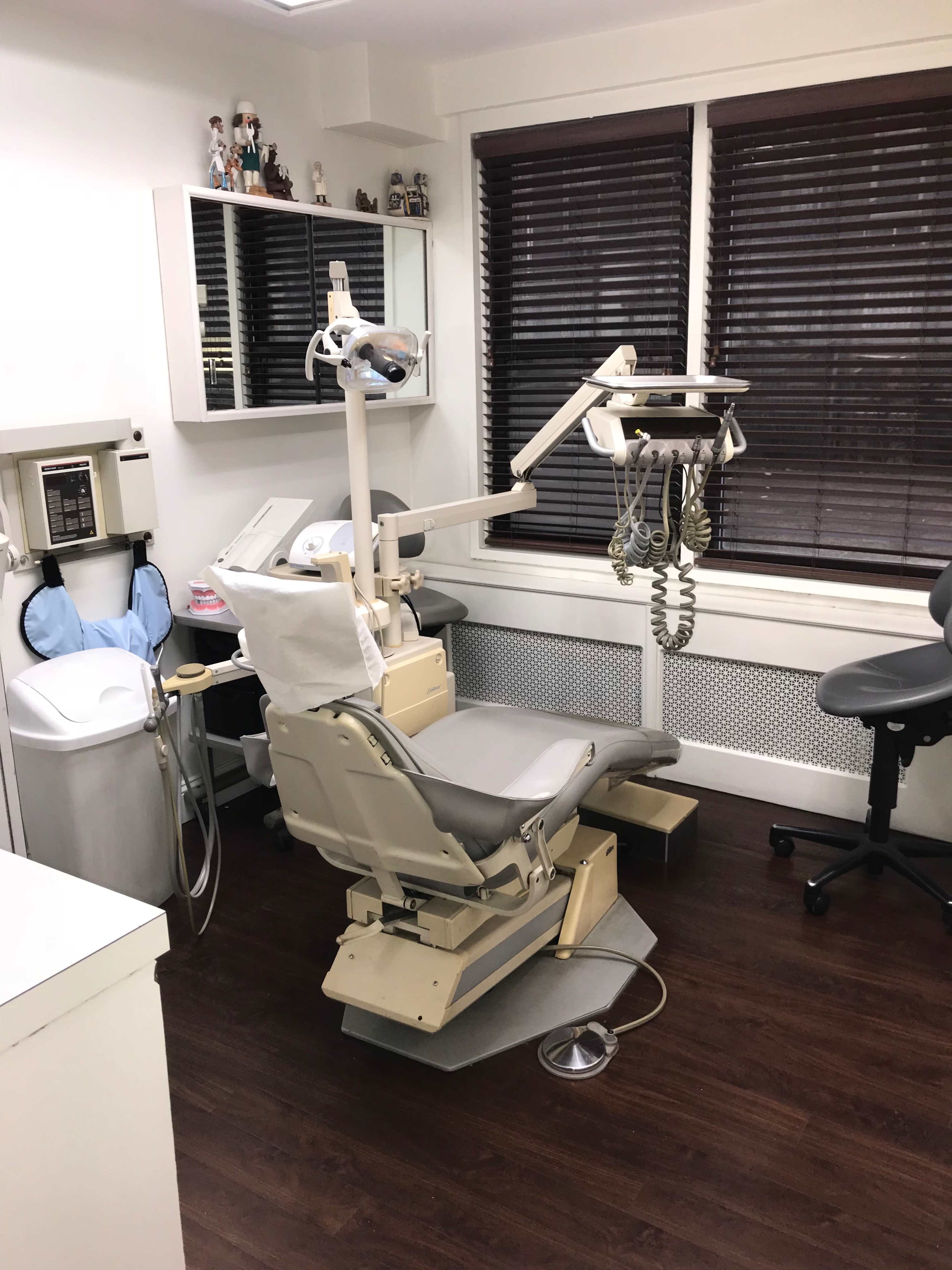 A dental office with a dental chair, equipment, and a workstation.