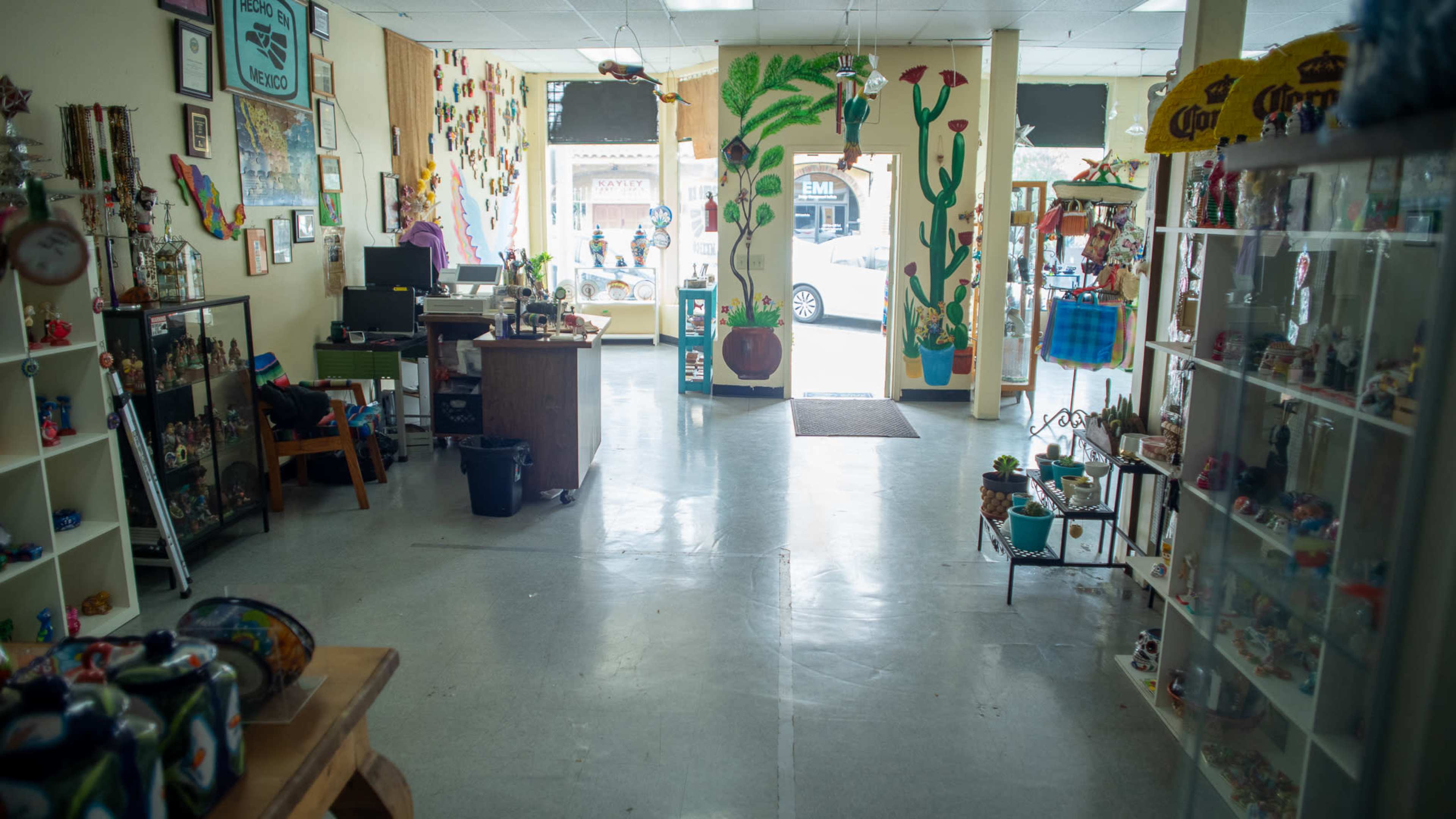 The interior of a store with colorful murals on the walls, displaying a variety of knick-knacks and merchandise for sale.