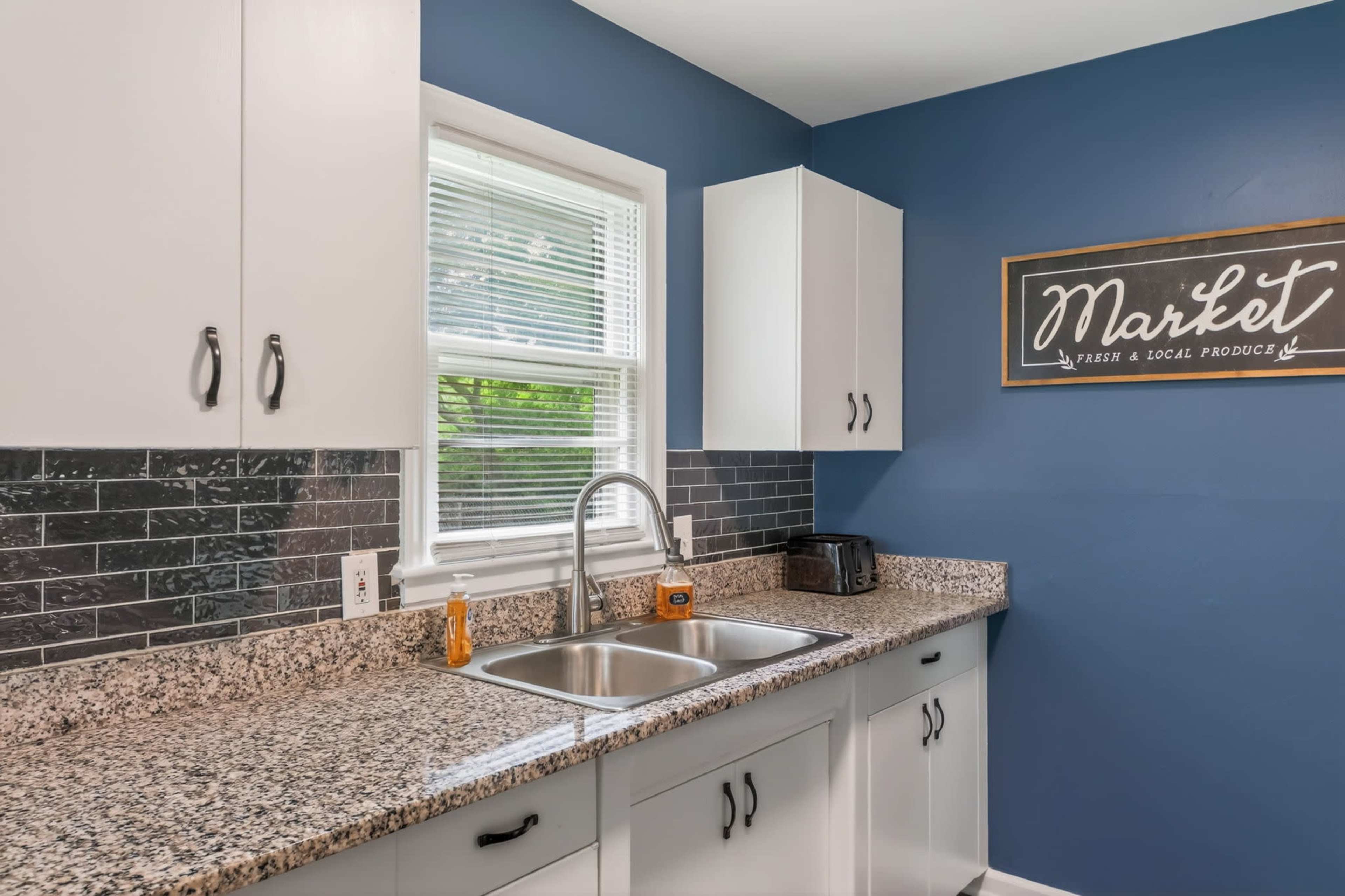 Moody Navy-Walled Bungalow with Bold Art & Backyard Image in Blue Township, Independence, MO