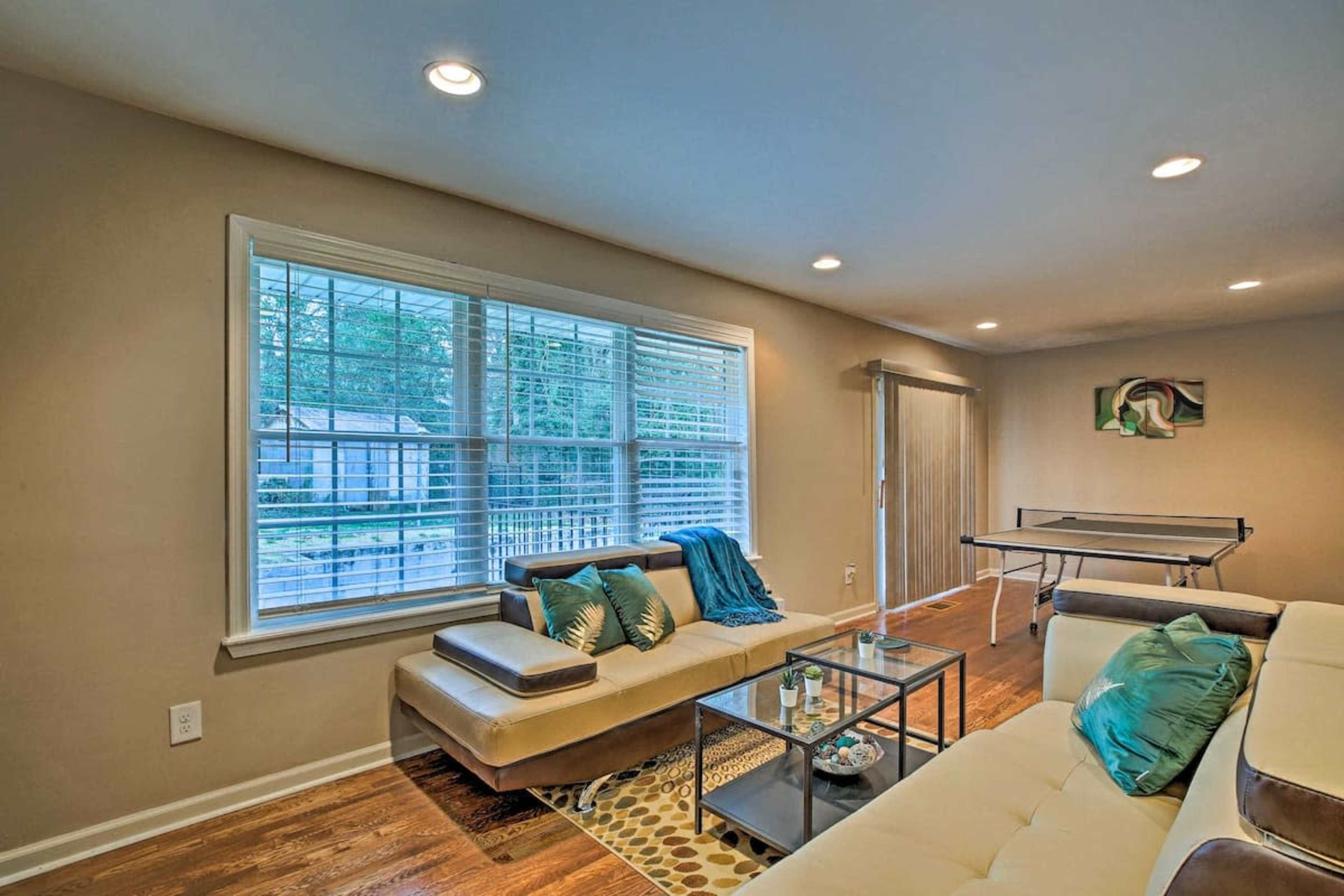 A modern living room with a sectional sofa, coffee table, and large windows overlooking an outdoor area.