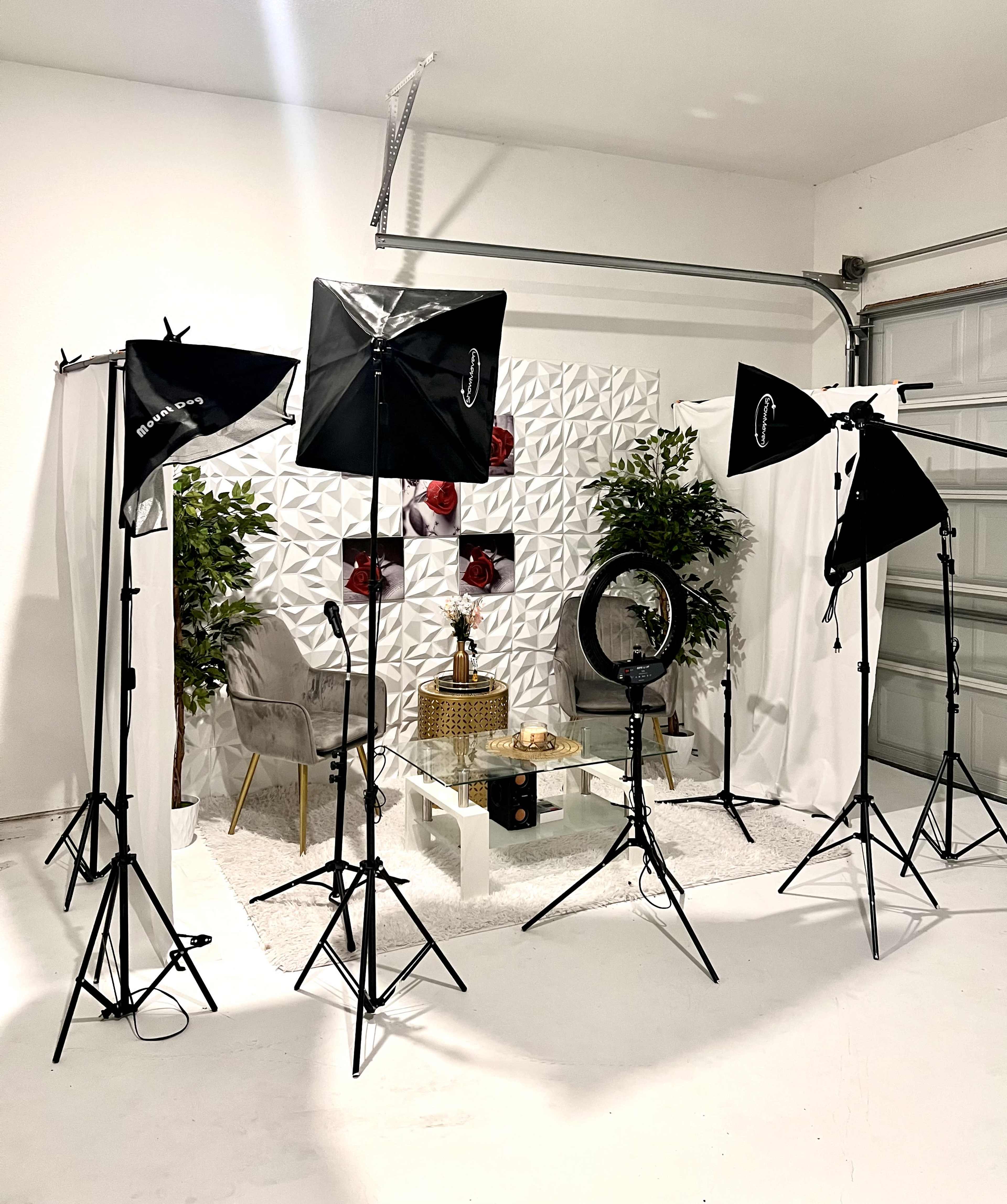 The image shows a well-organized filming setup featuring studio lights, a circular mirror, and decorative elements, arranged in a minimalist space.