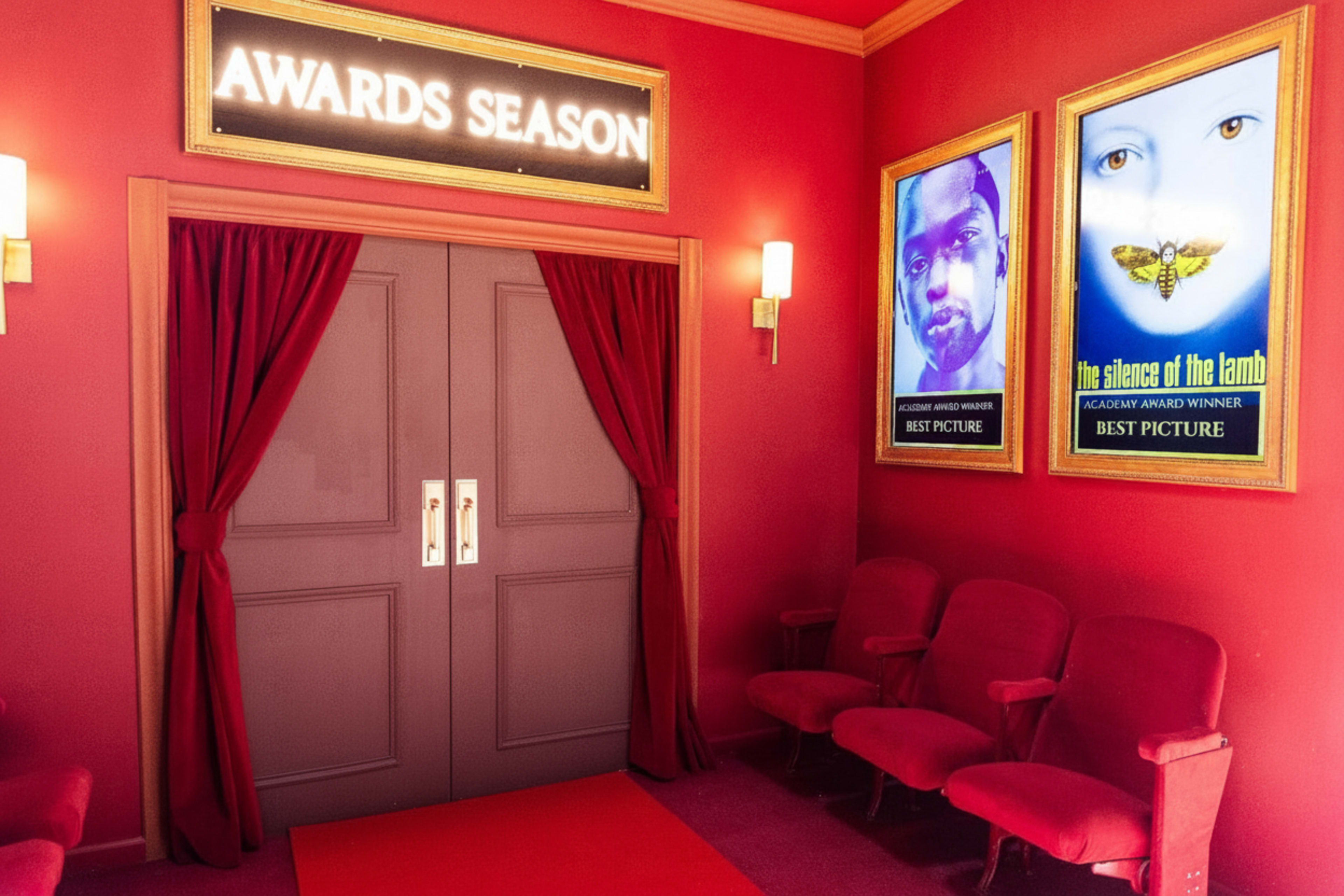 A red-themed room features a set of double doors labeled "AWARDS SEASON" and two framed movie posters on the walls, with empty red velvet seats arranged in front.