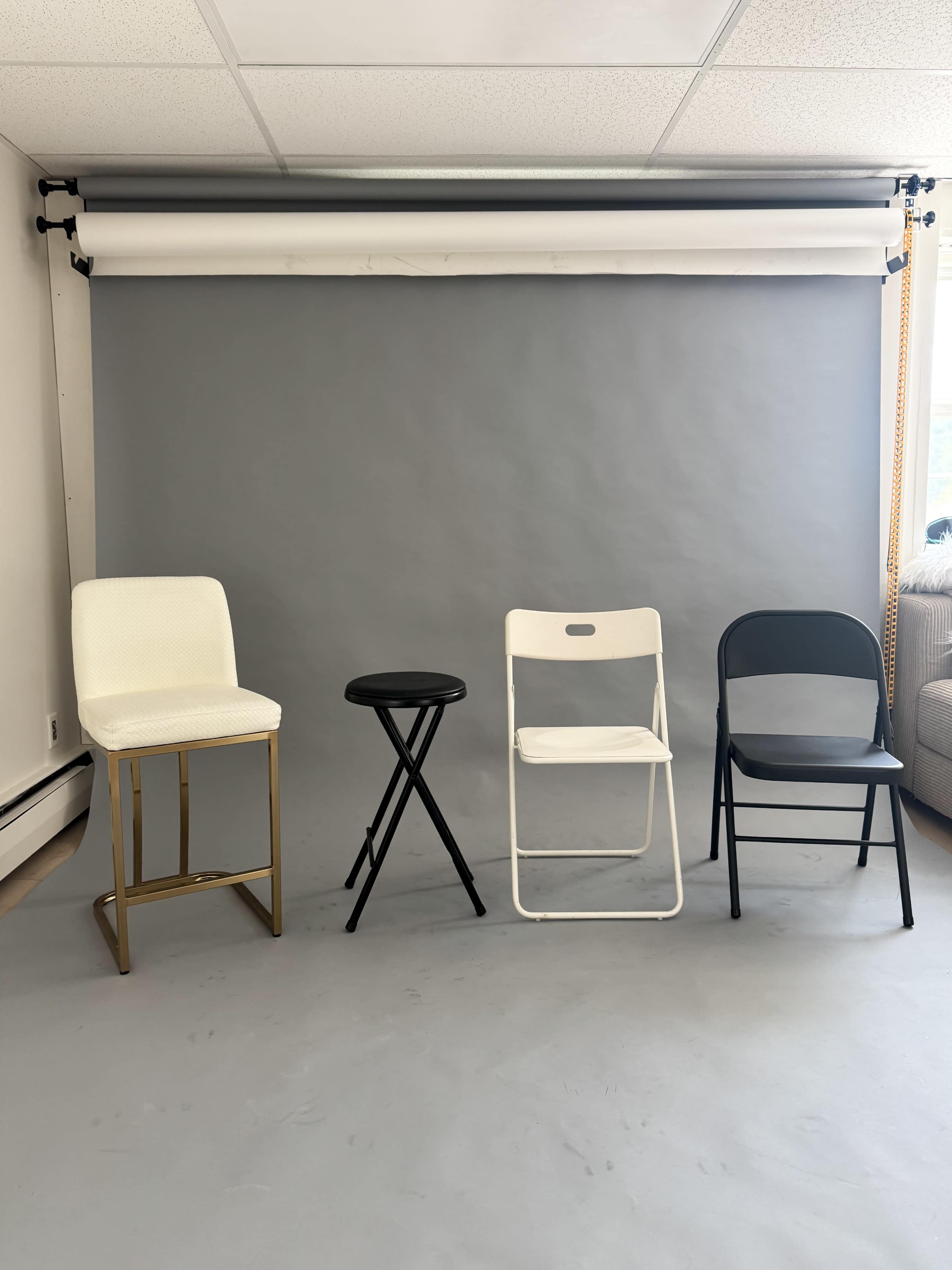 The image shows four different types of chairs arranged in a row against a gray background.