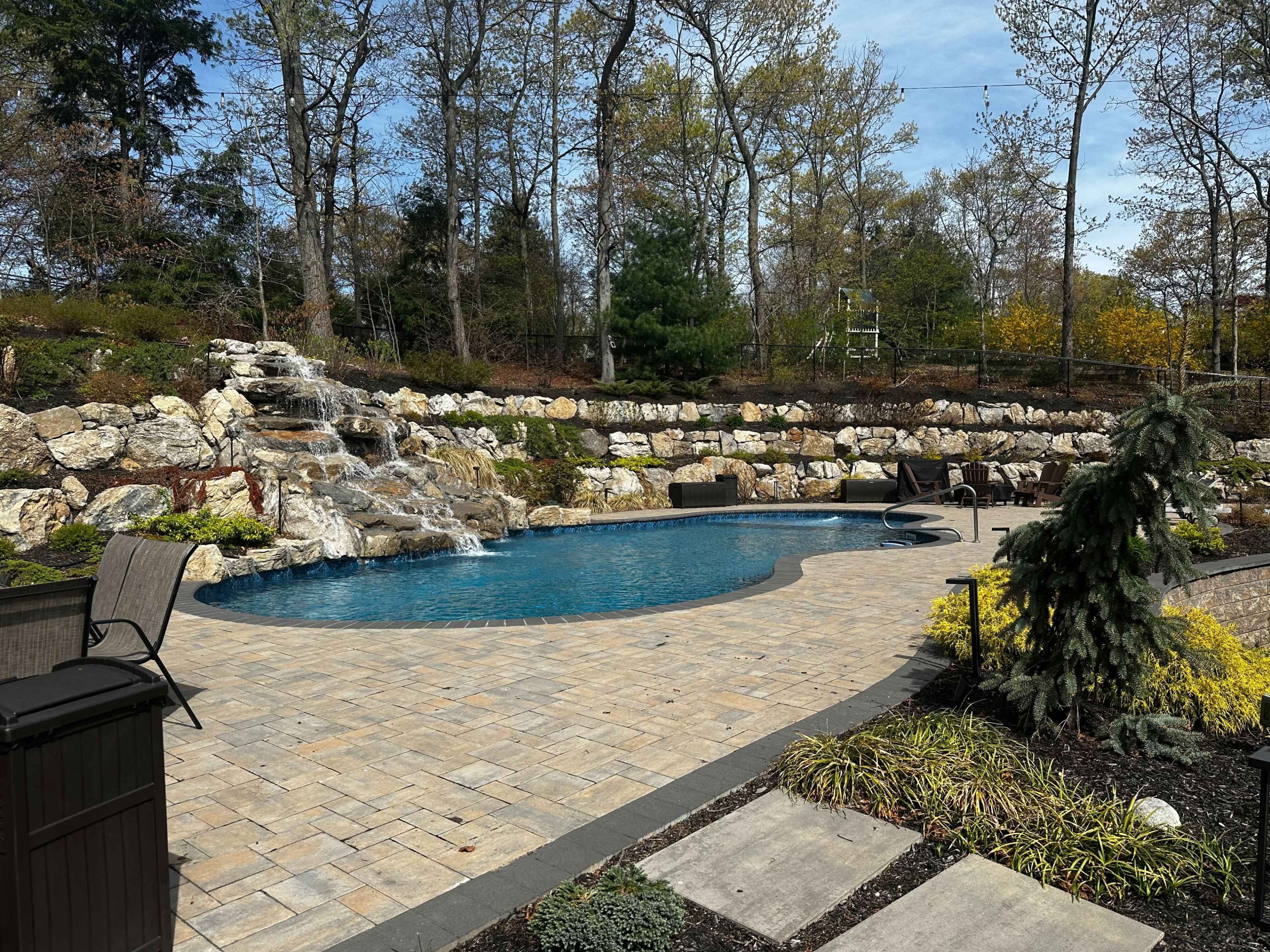 Resort style backyard with pool, pavilion, surround sound speakers and grills Image in Huntington, Melville, NY