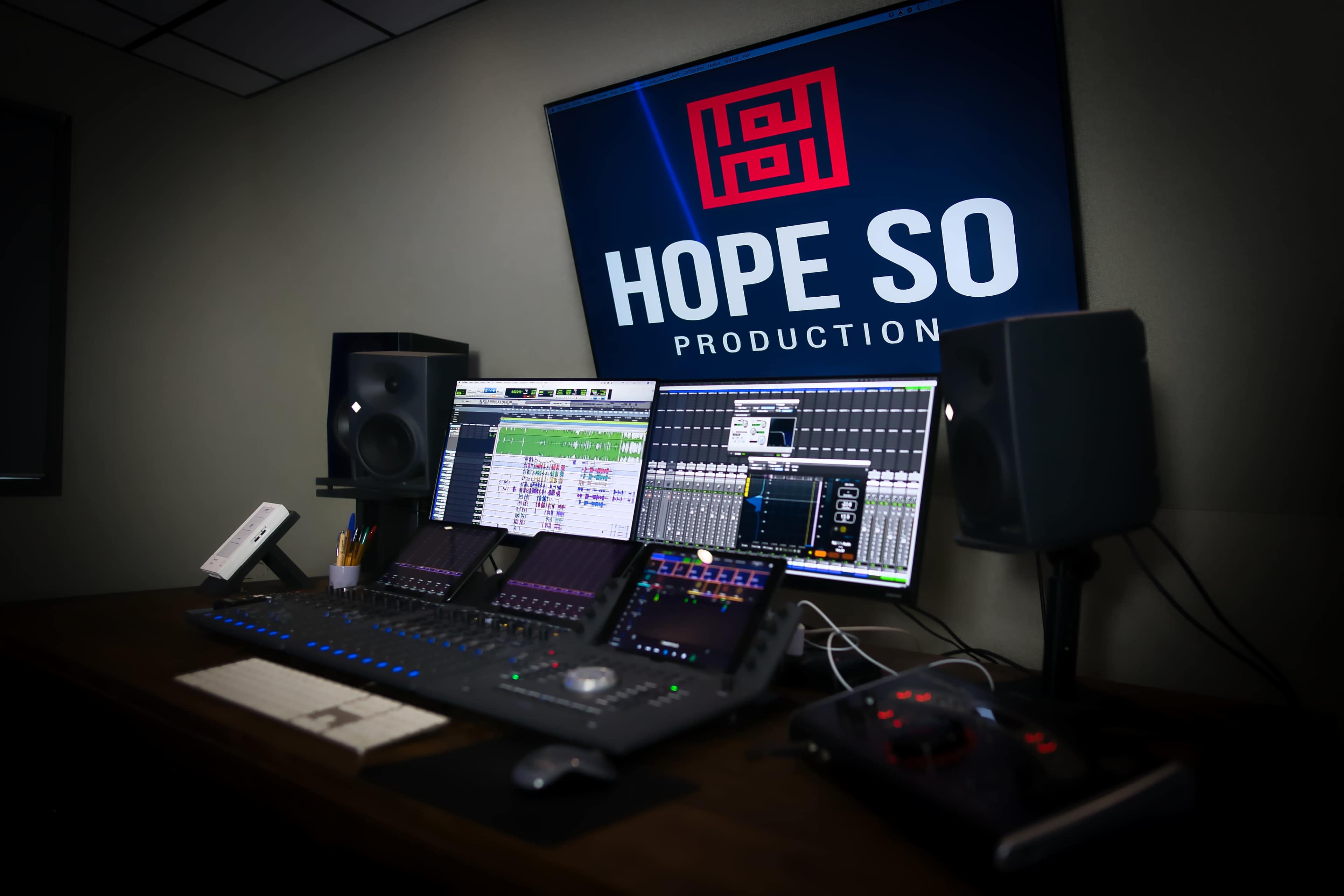 A digital audio workstation setup is shown, featuring multiple monitors, audio equipment, and a "Hope So Production" logo on the wall.