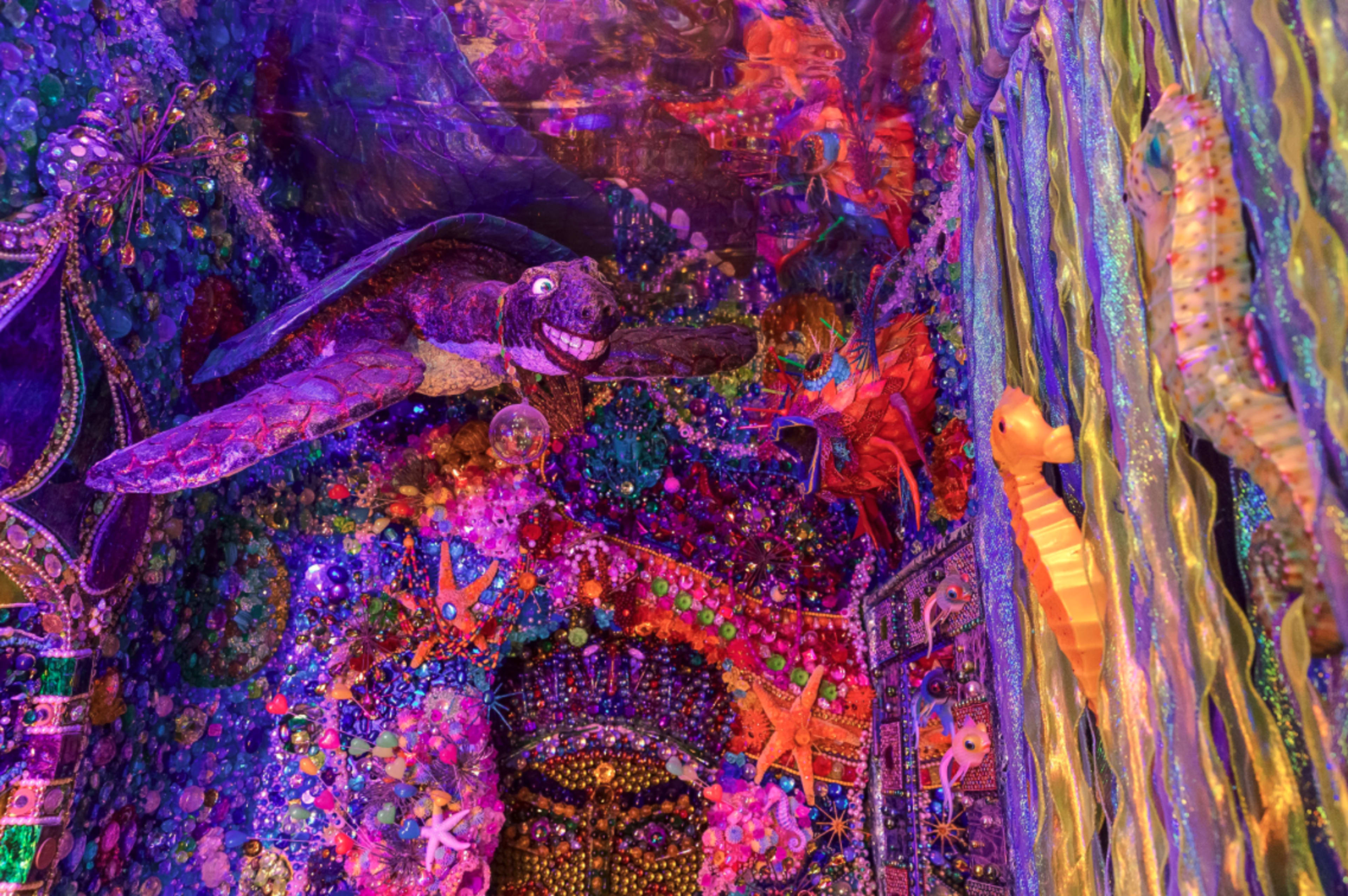 The image features a vibrant underwater scene adorned with a three-dimensional turtle and other colorful marine motifs against a backdrop of elaborate decorations.