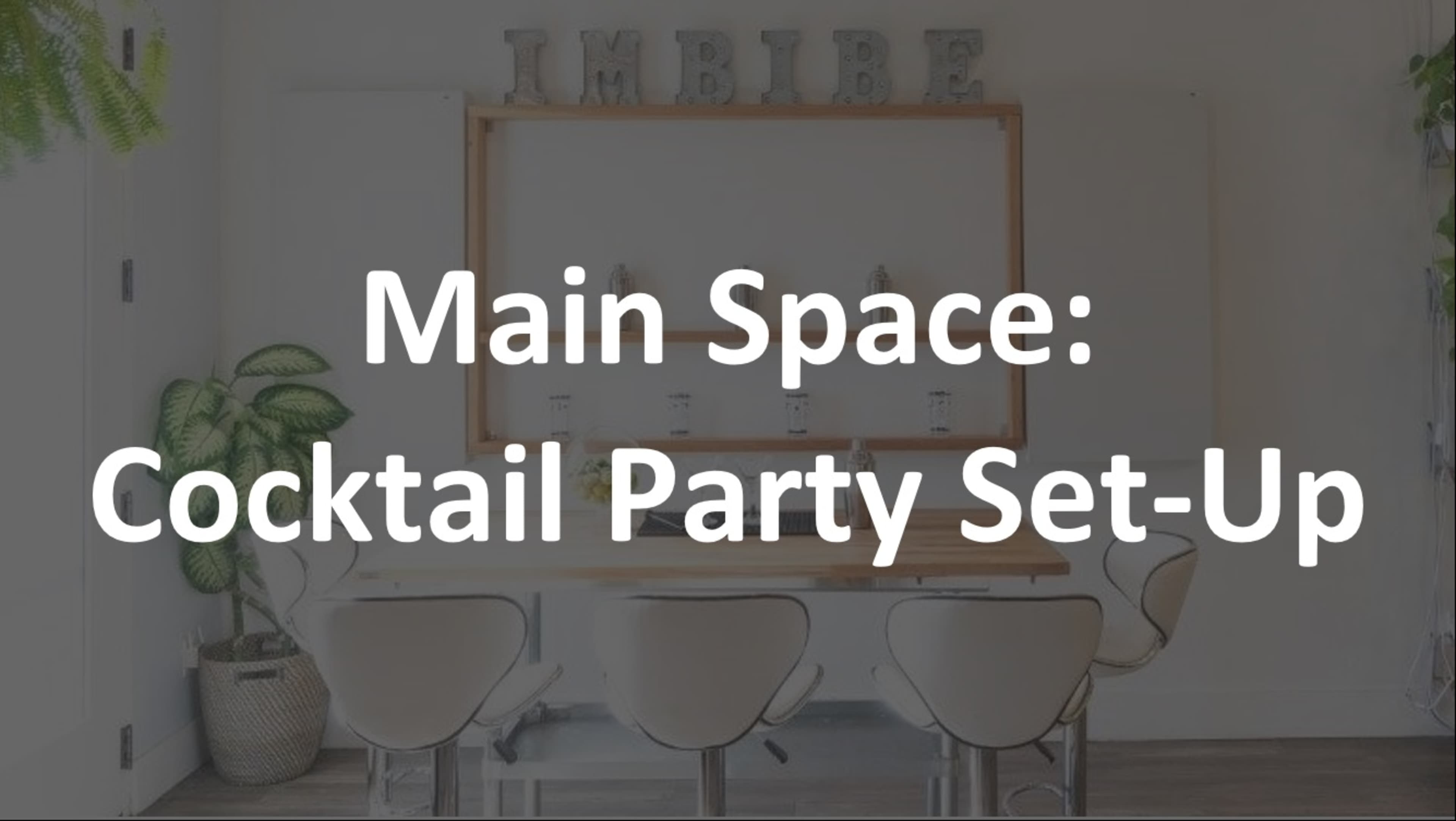 A modern dining area arranged for a cocktail party, with a long table, chairs, and decorative elements prominently displayed.