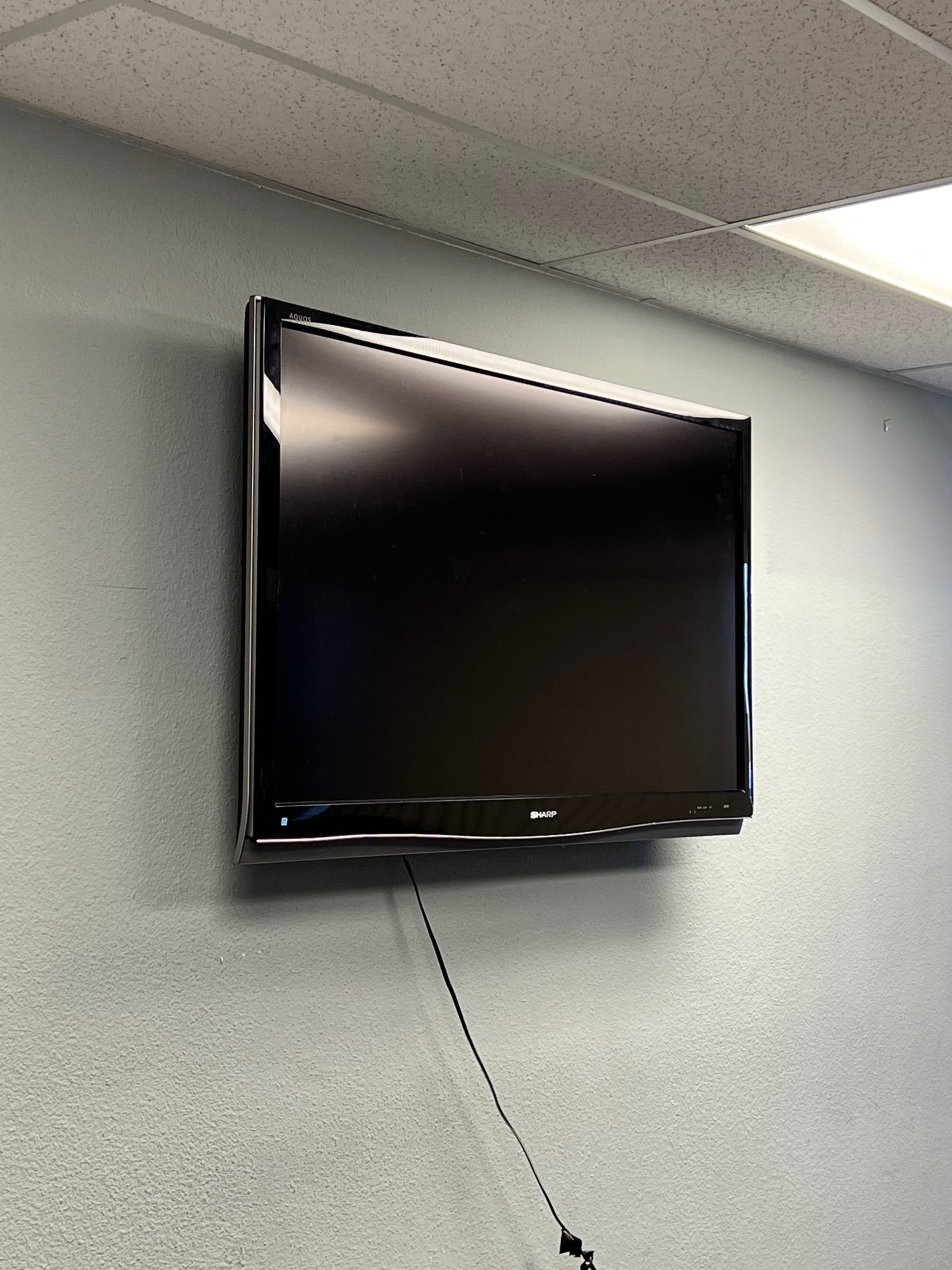 A flat-screen television is mounted on a light blue wall.