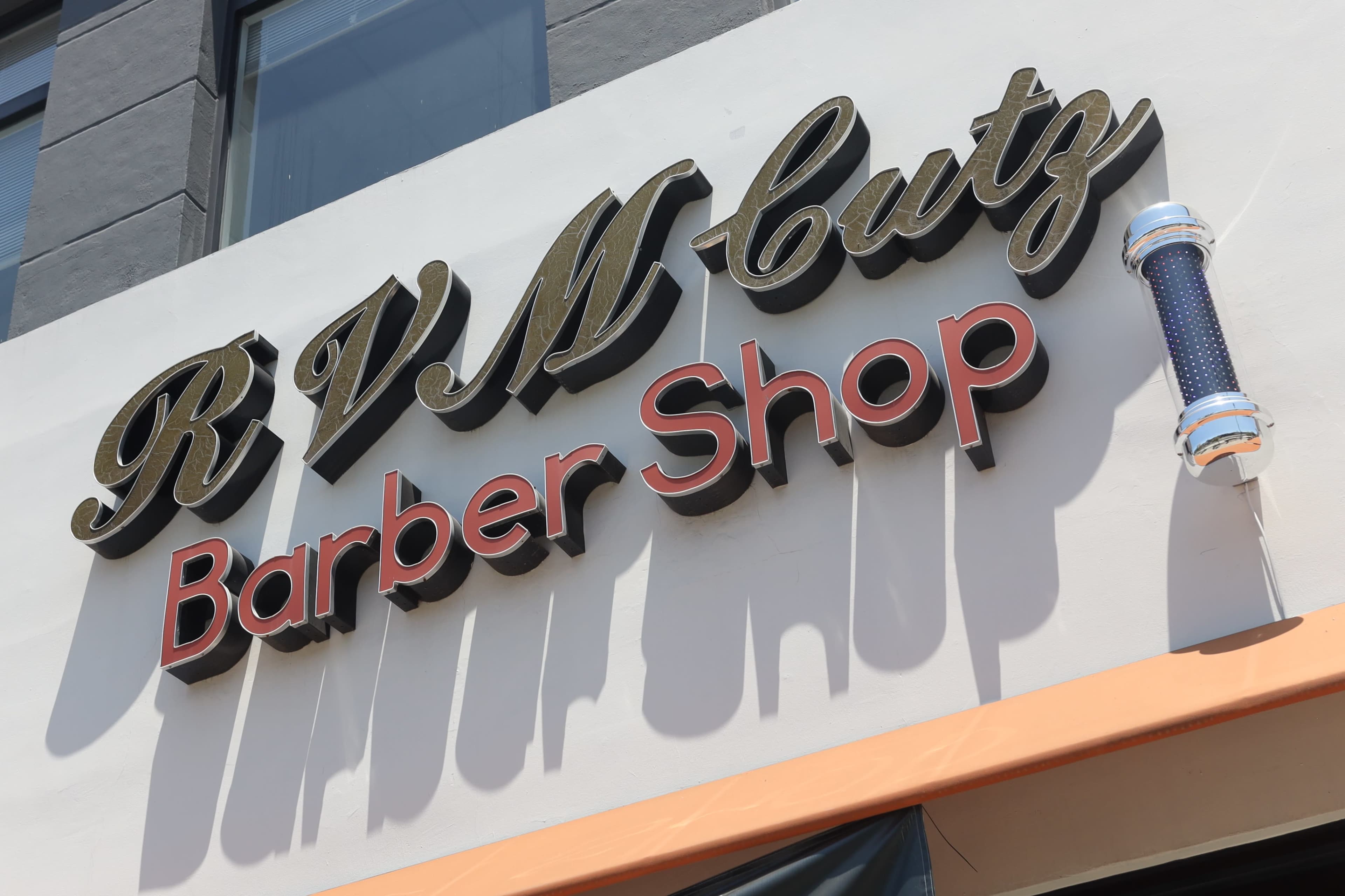 A barber shop sign that reads "RVM Cutz" in bold letters, with "Barber Shop" displayed underneath.